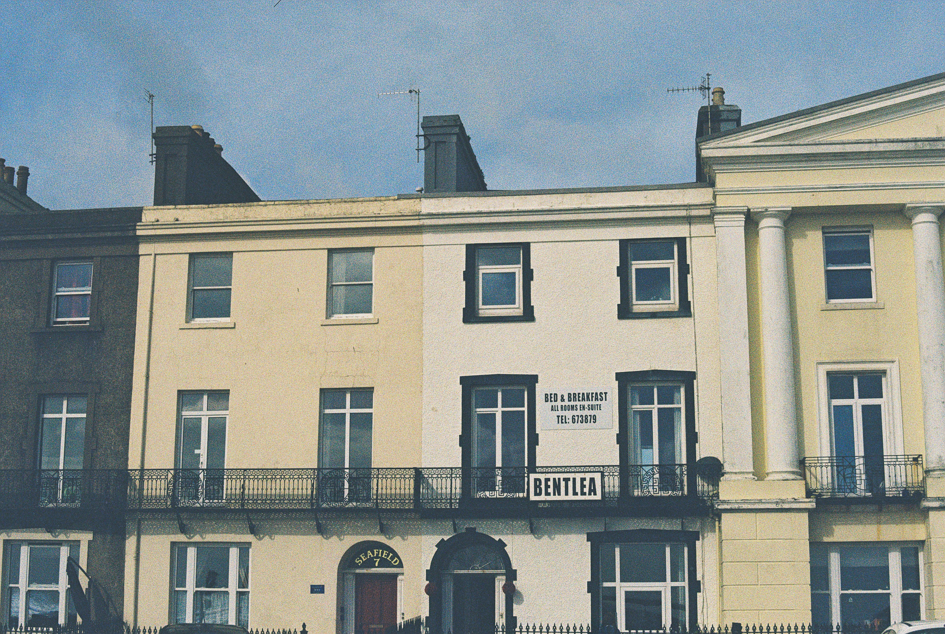 A row of historic townhouses with a sign reading Bentlea bed and breakfast