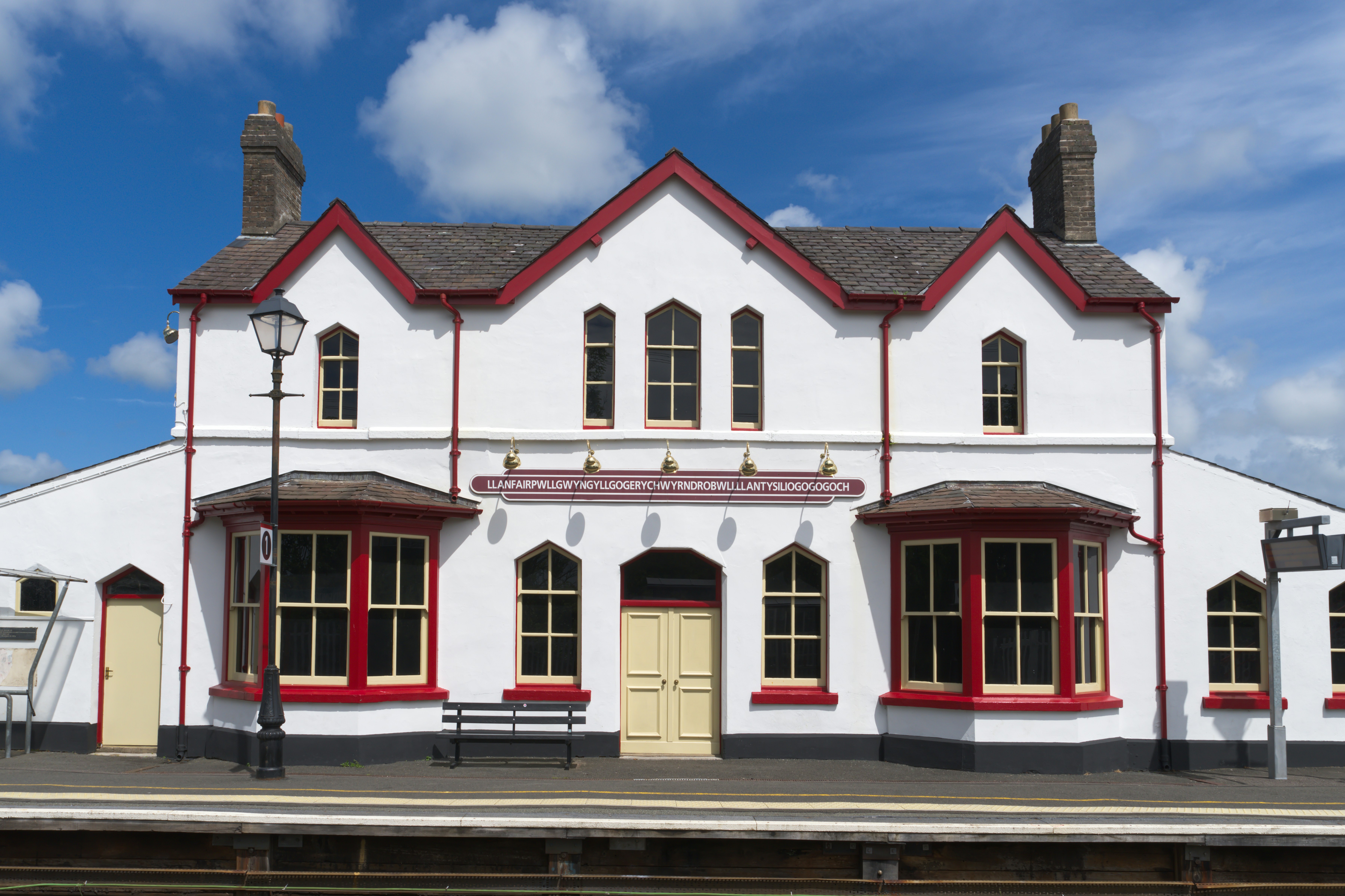 The white railway station building in Llanfairpwllgwyngyll with red trim and a long name sign
