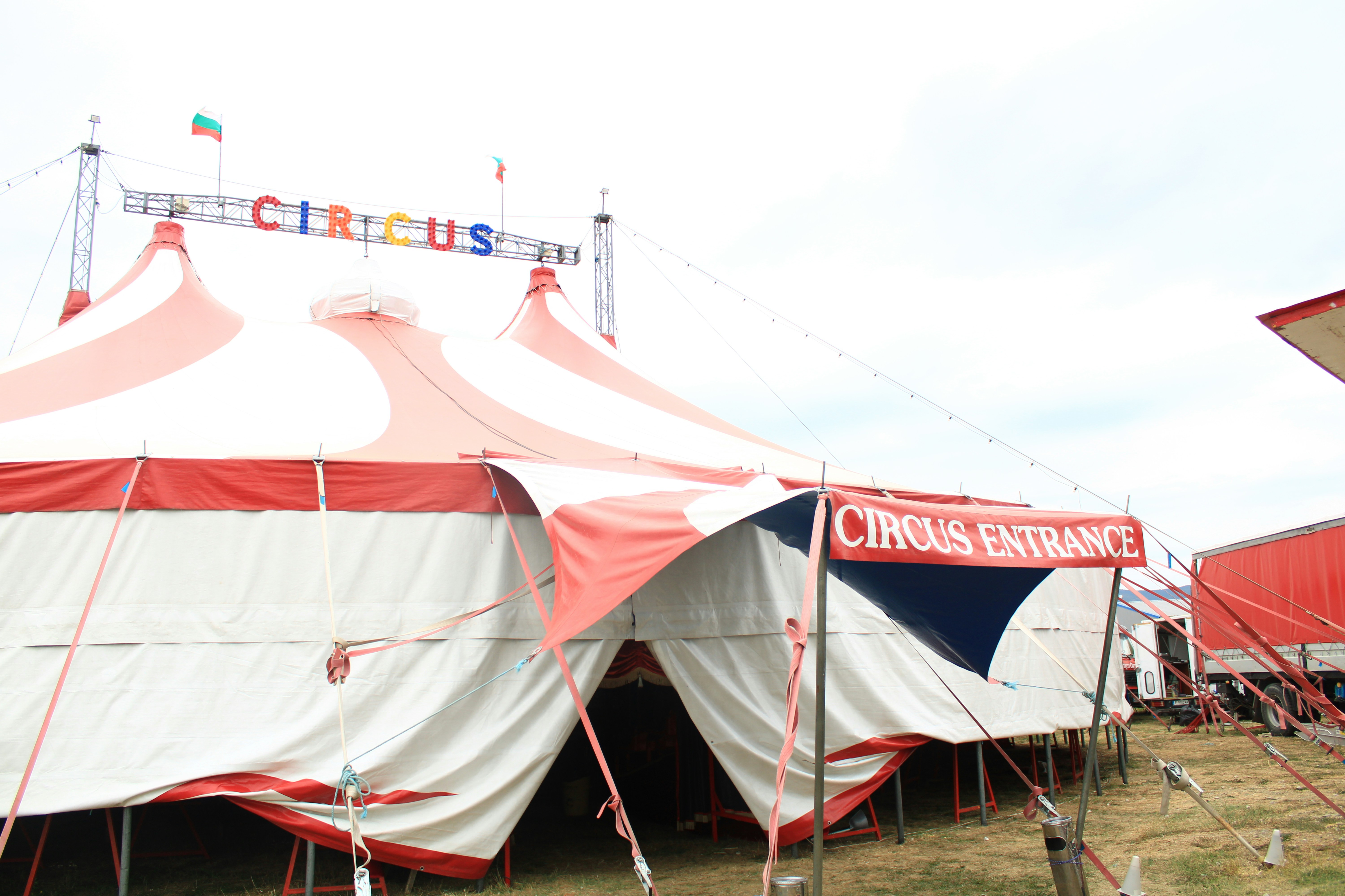「CIRCUS ENTRANCE」と書かれた看板が掲げられた赤と白のストライプのサーカステント