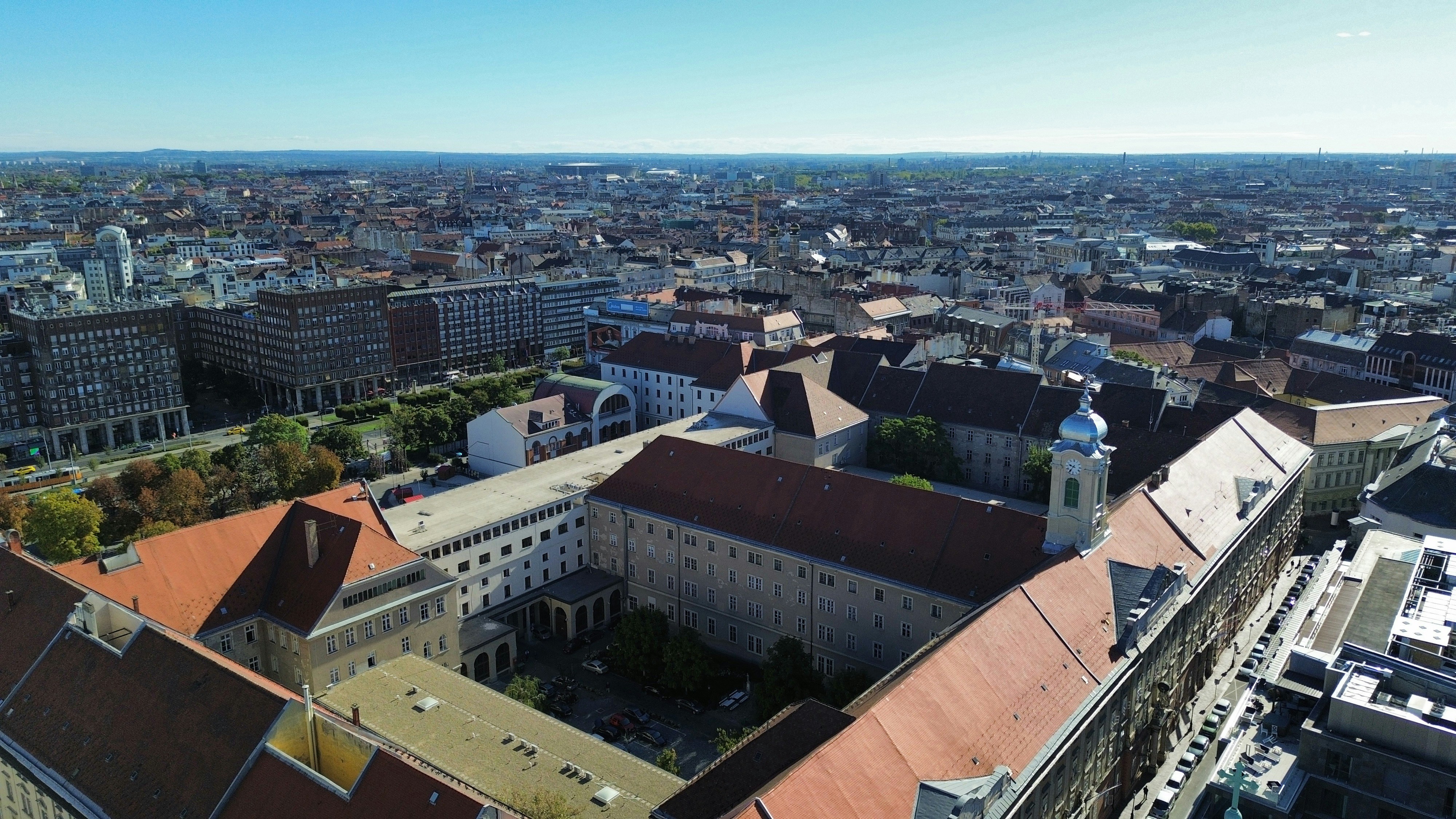 Aerial view of a large historic building complex with red roofs in Budapest