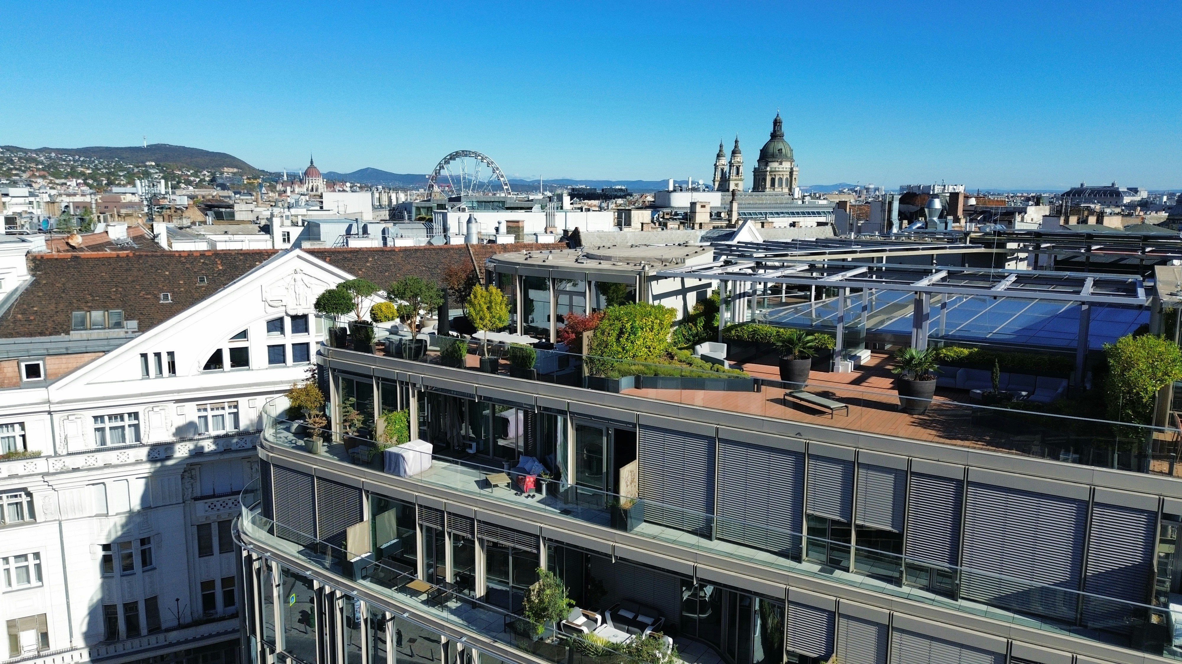 Aerial view of a rooftop terrace with plants overlooking the city of Budapest