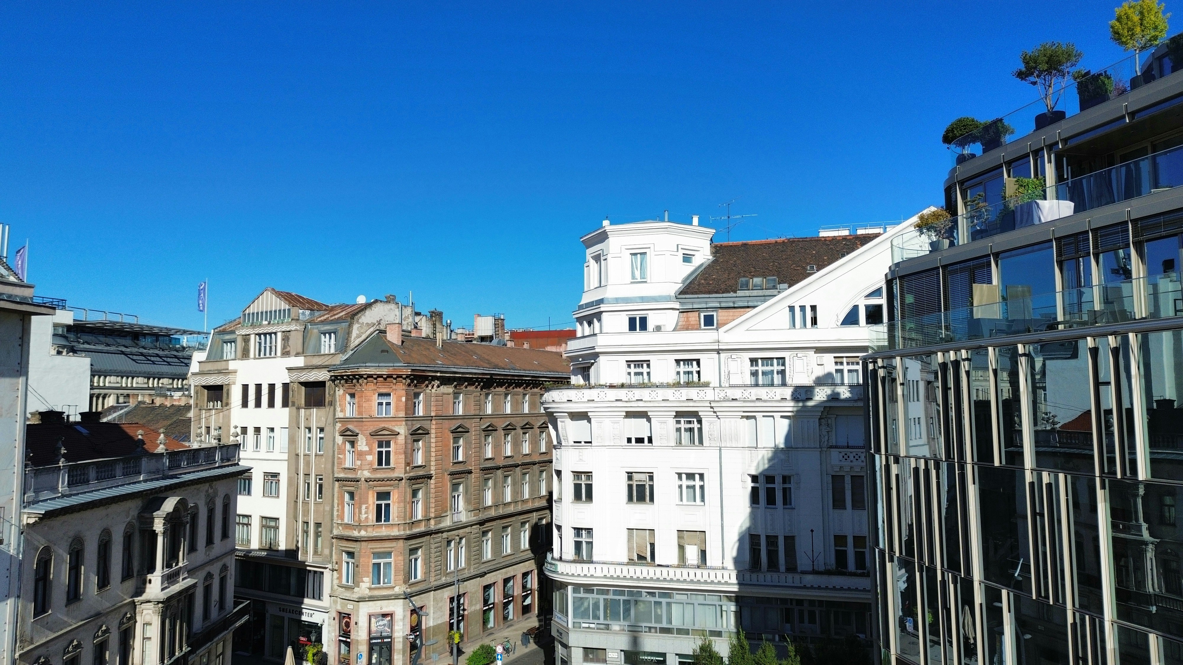 Historic and modern buildings under a clear blue sky in a city center
