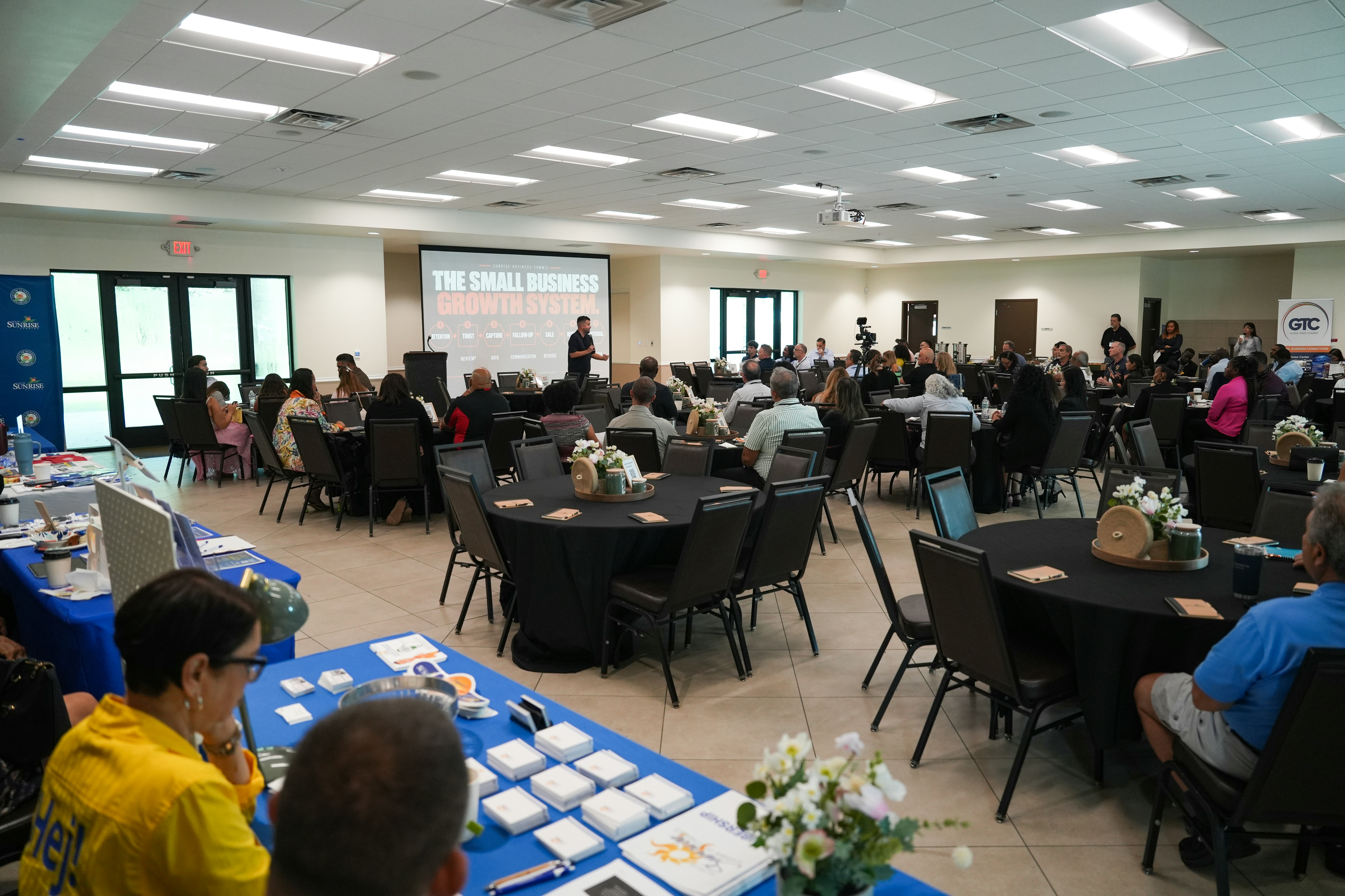 A speaker presenting to a group of people at a business conference