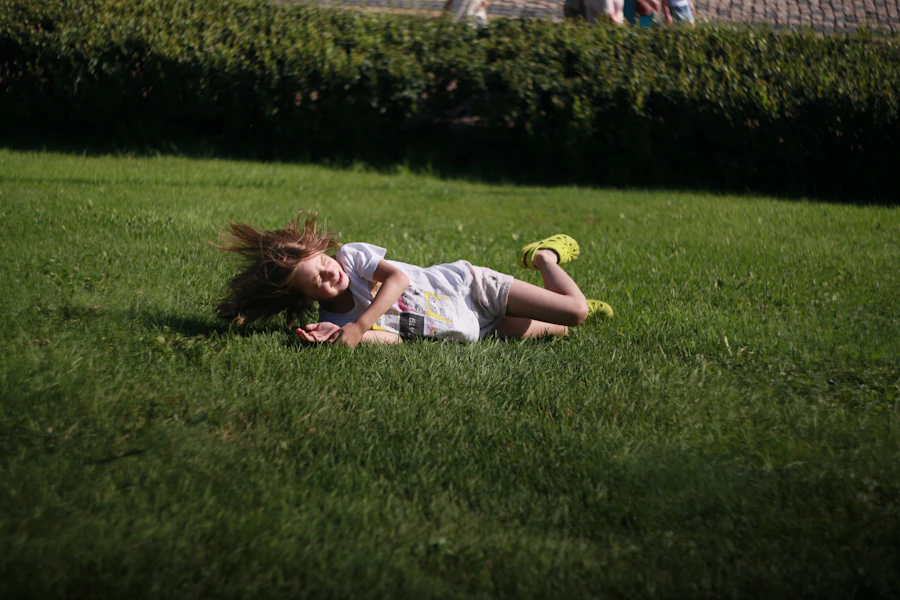 Child lying on green grass