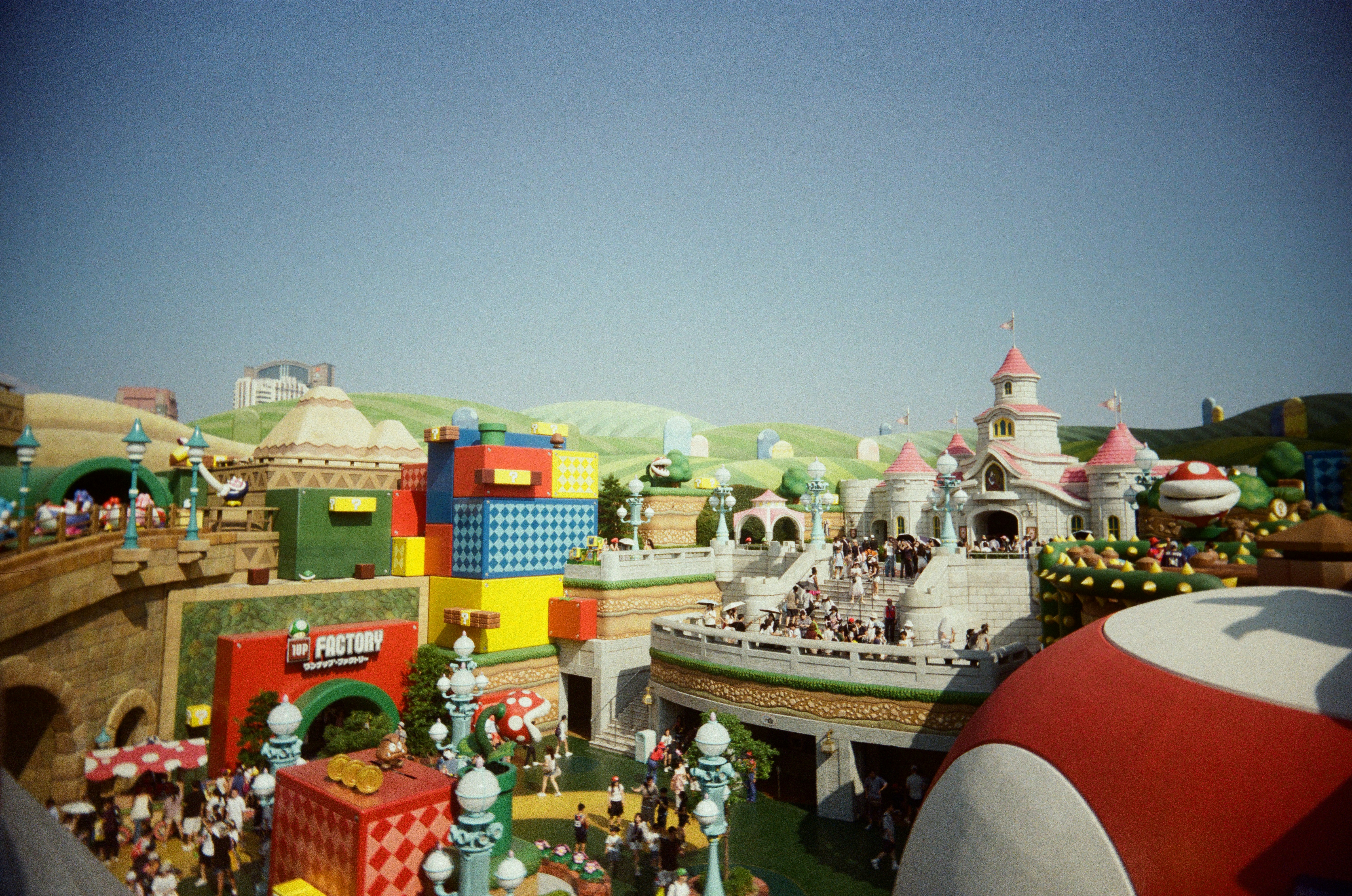 A colorful theme park with a castle and block structures under a clear sky