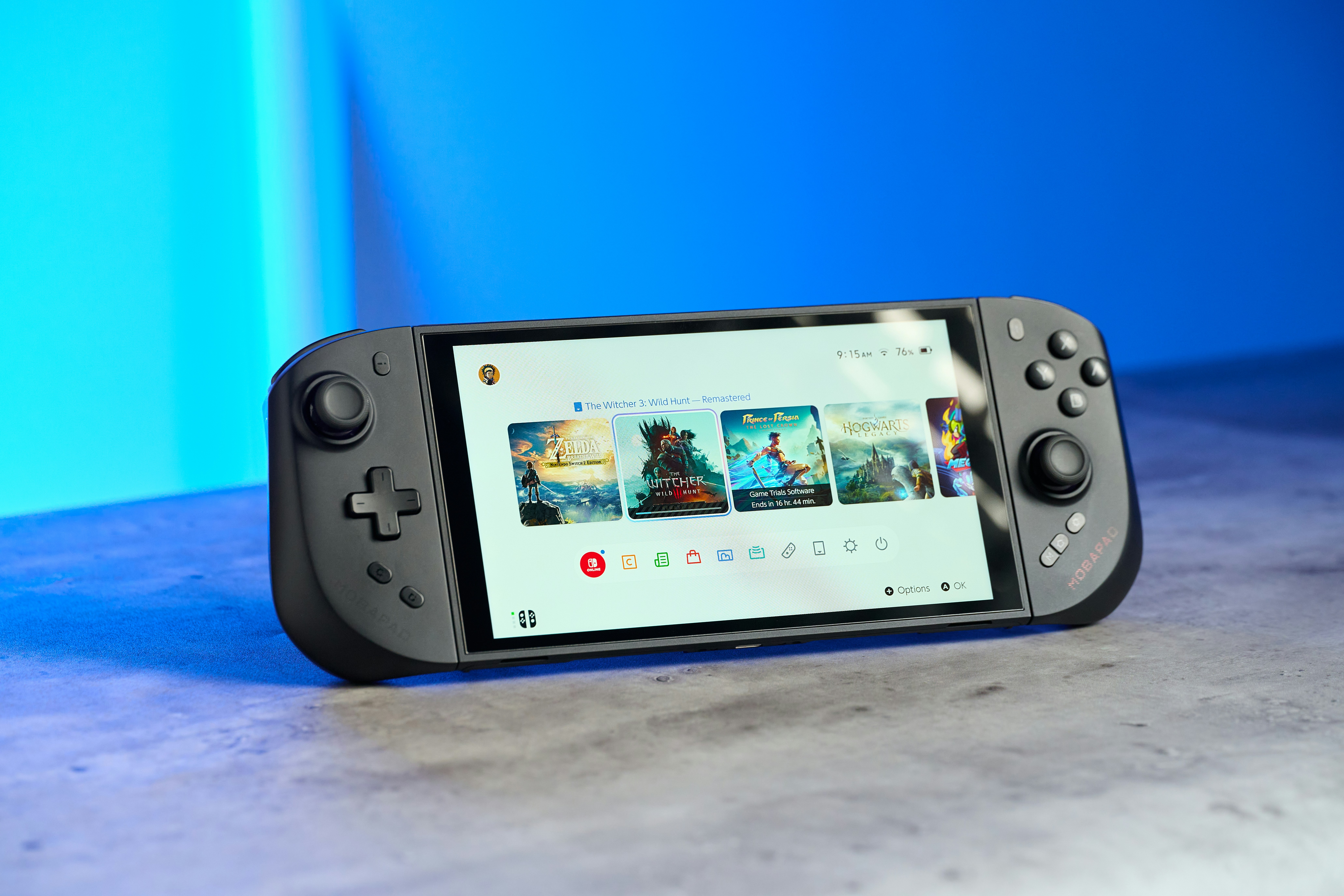 A handheld gaming console with a screen displaying a menu on a grey surface
