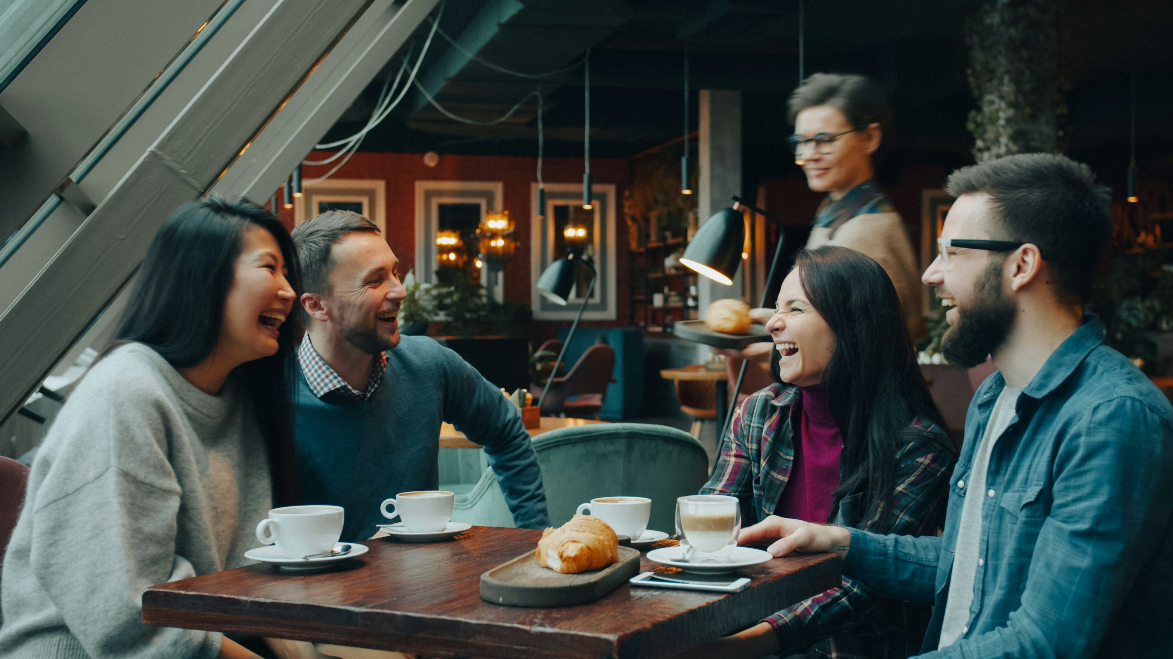 Des clients trinquent à une table de restaurant.