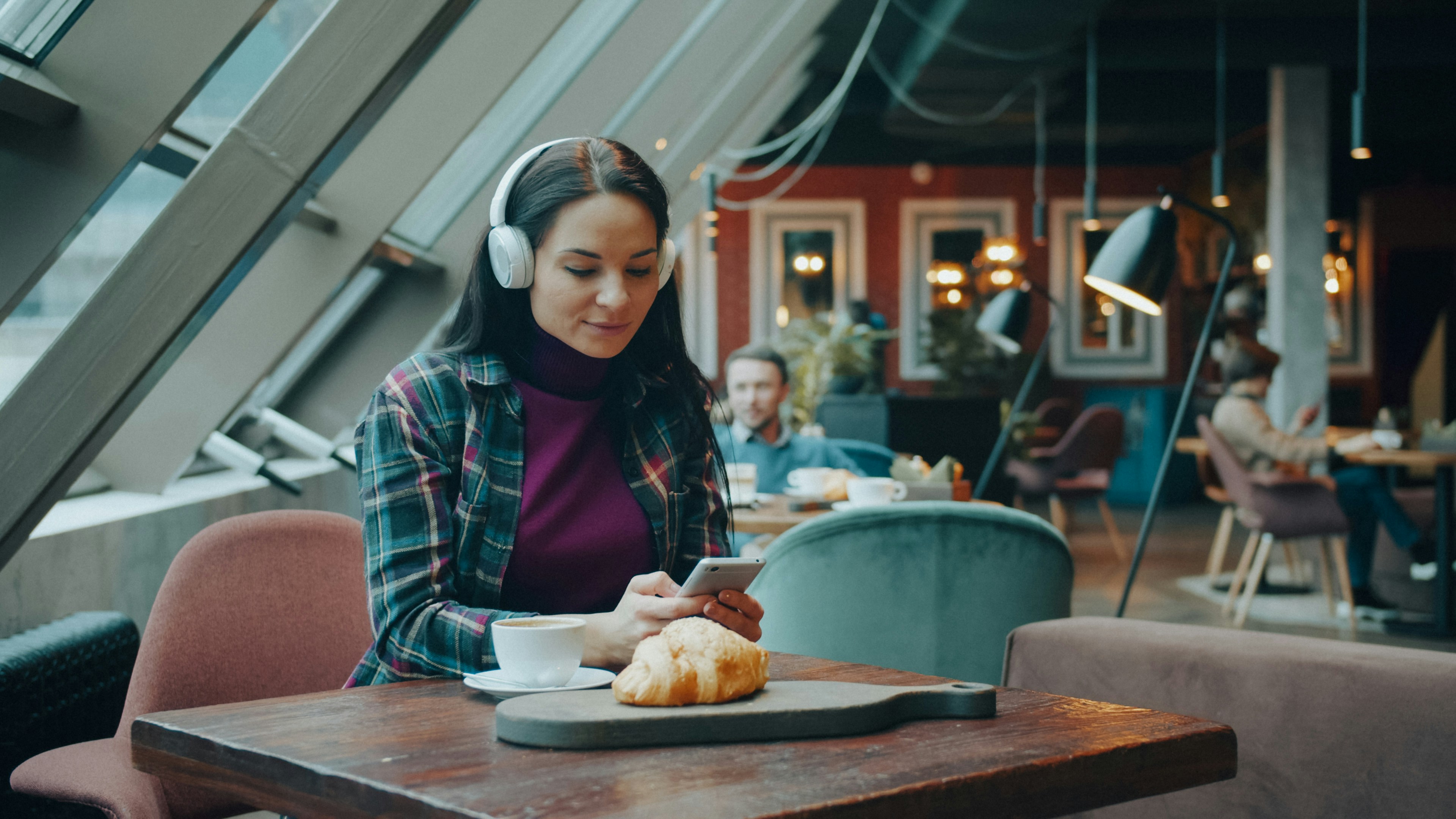 Woman with headphones studying in a cafe