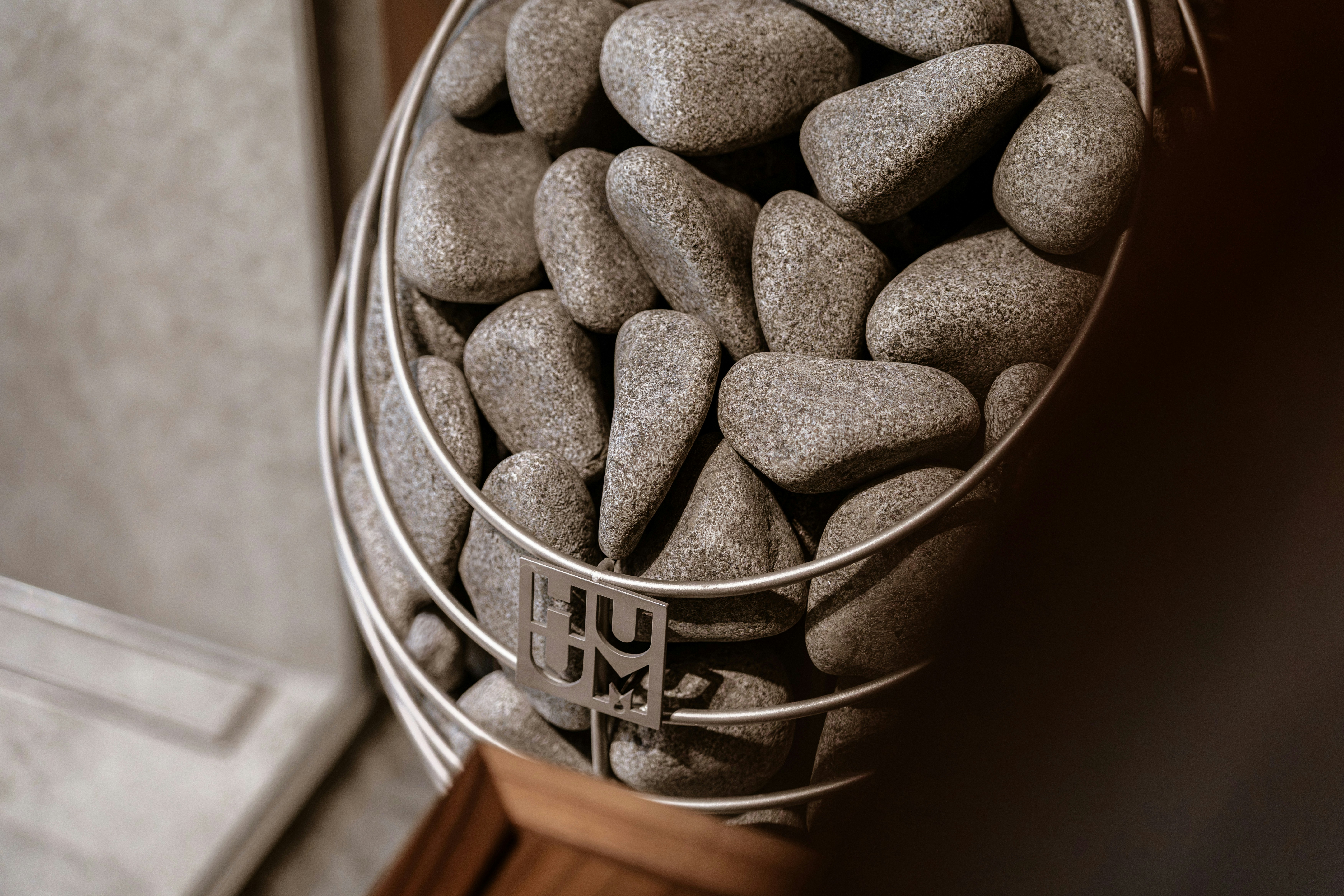 Smooth grey stones stacked inside a metal wire heater basket