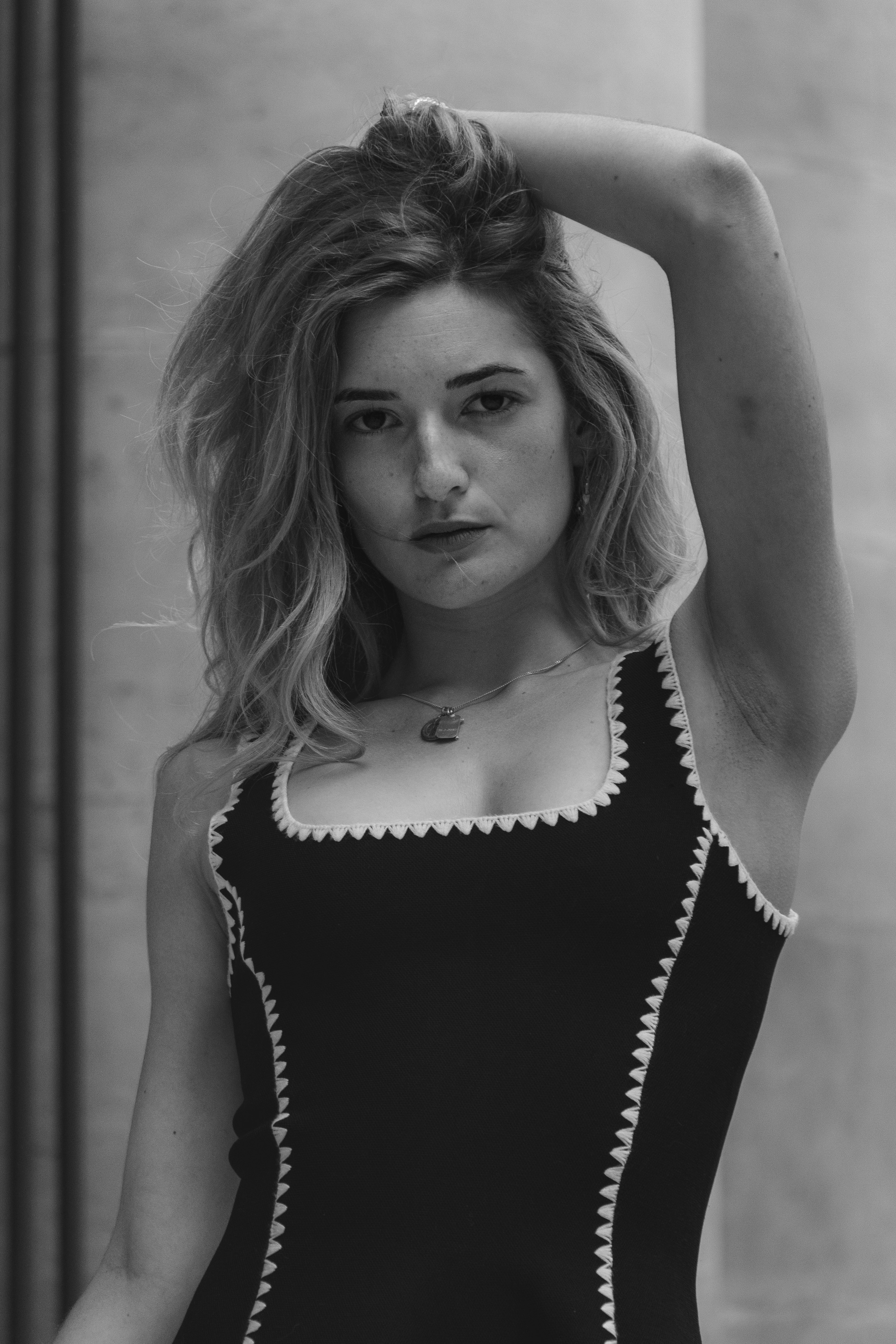A woman with wavy hair wearing a black tank top with white trim