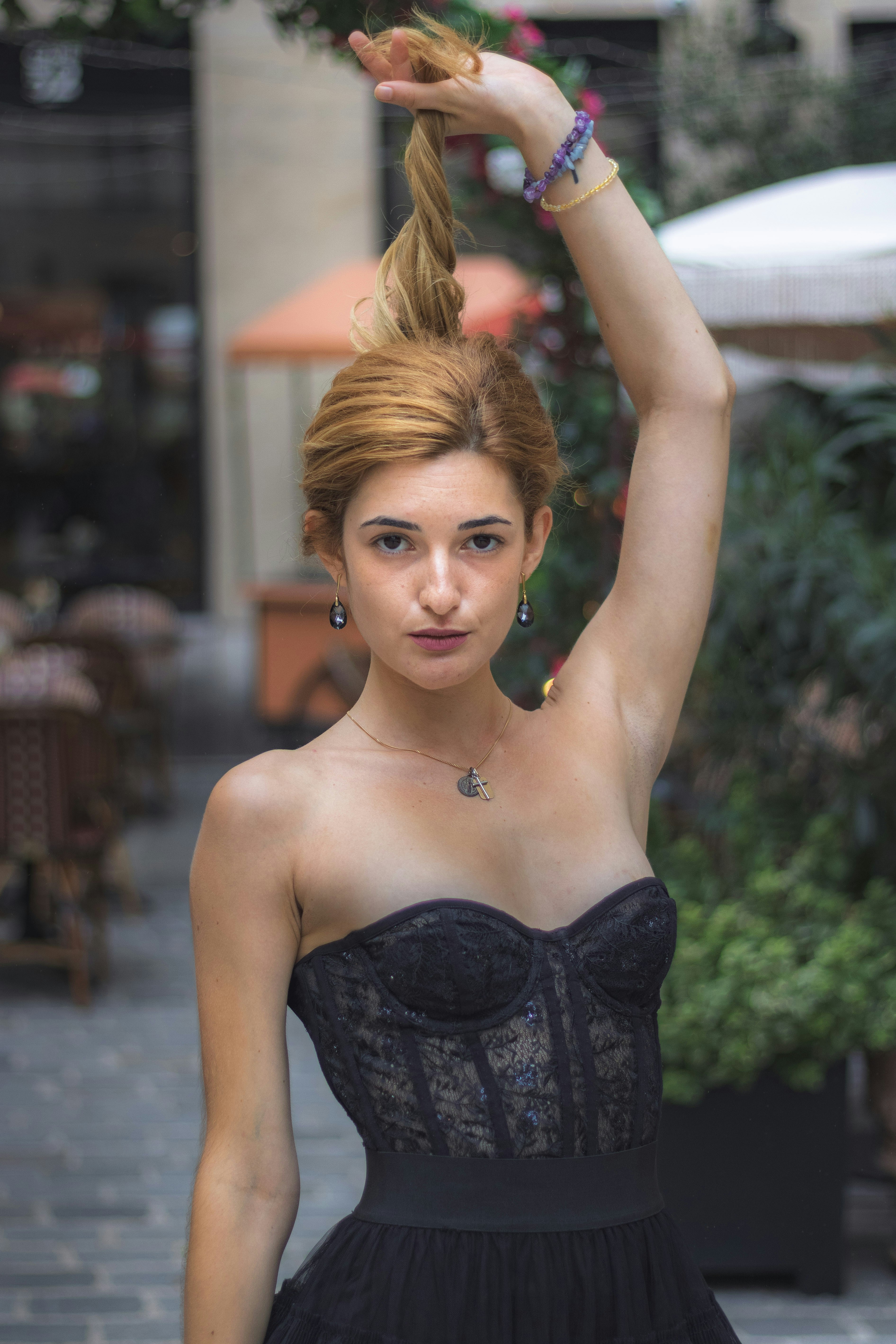 Uma mulher com um espartilho de renda preta segurando o cabelo preso em um coque