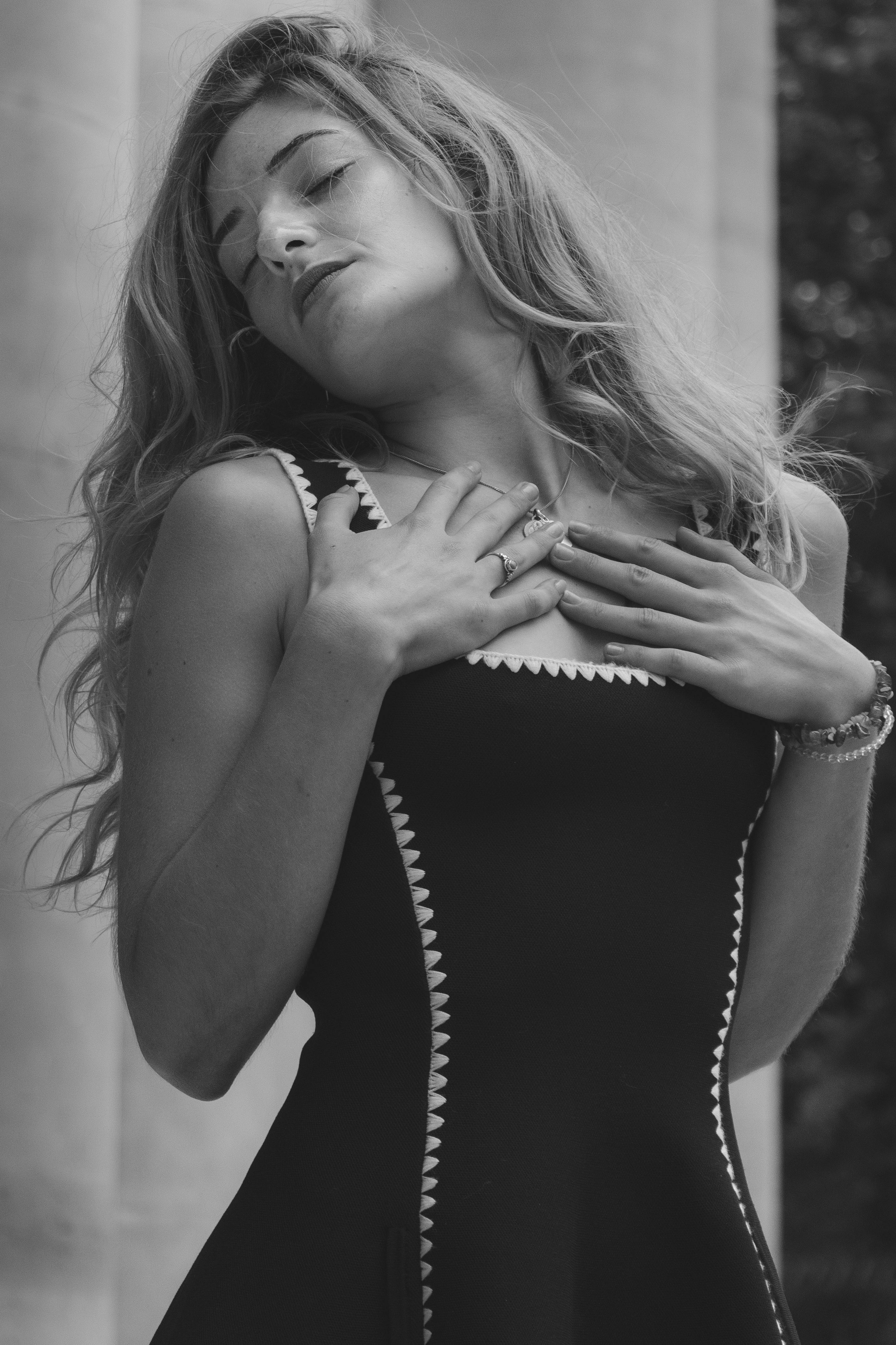 A woman with long wavy hair in a black dress with white trim