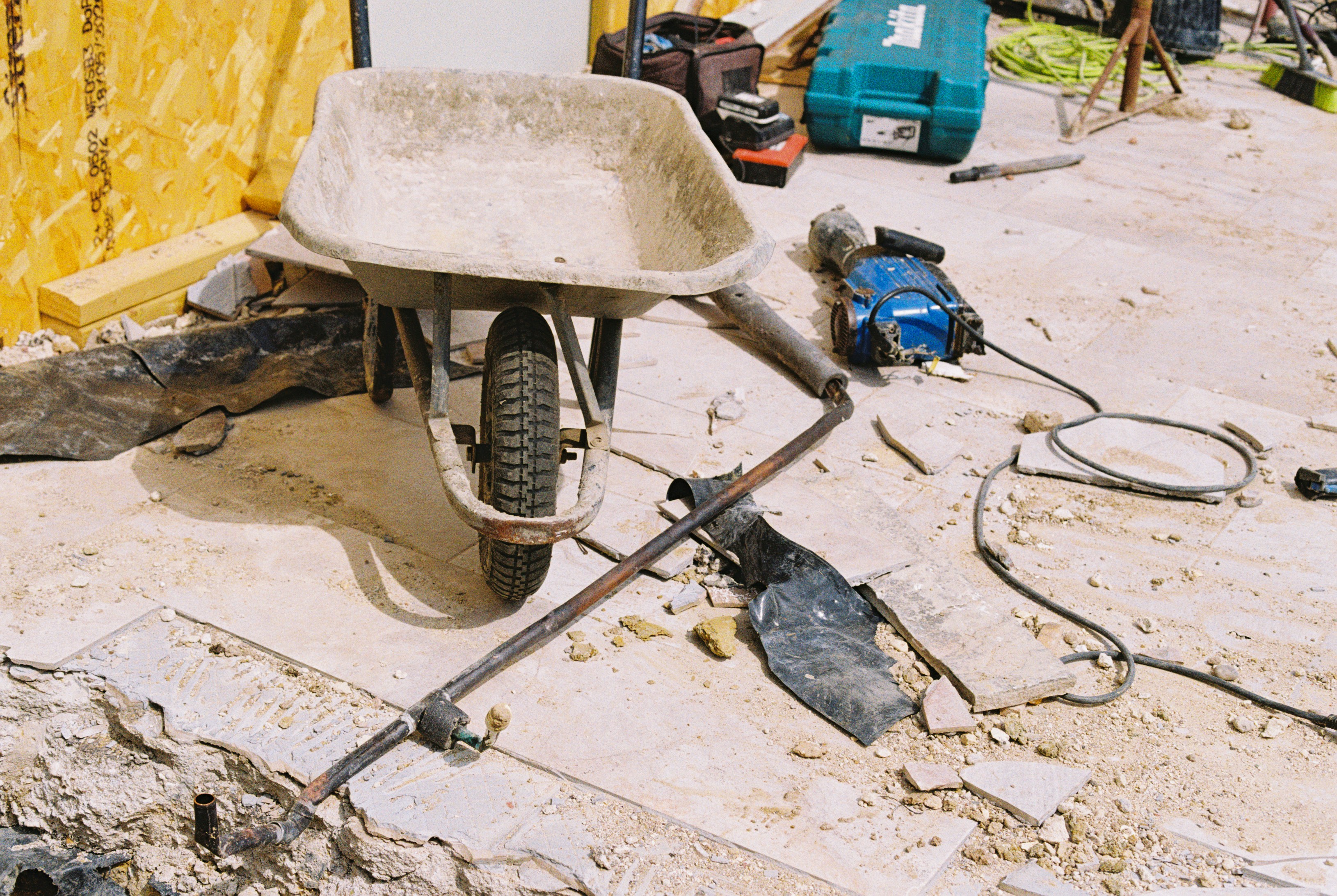 Wheelbarrow and tools on a dusty renovation site