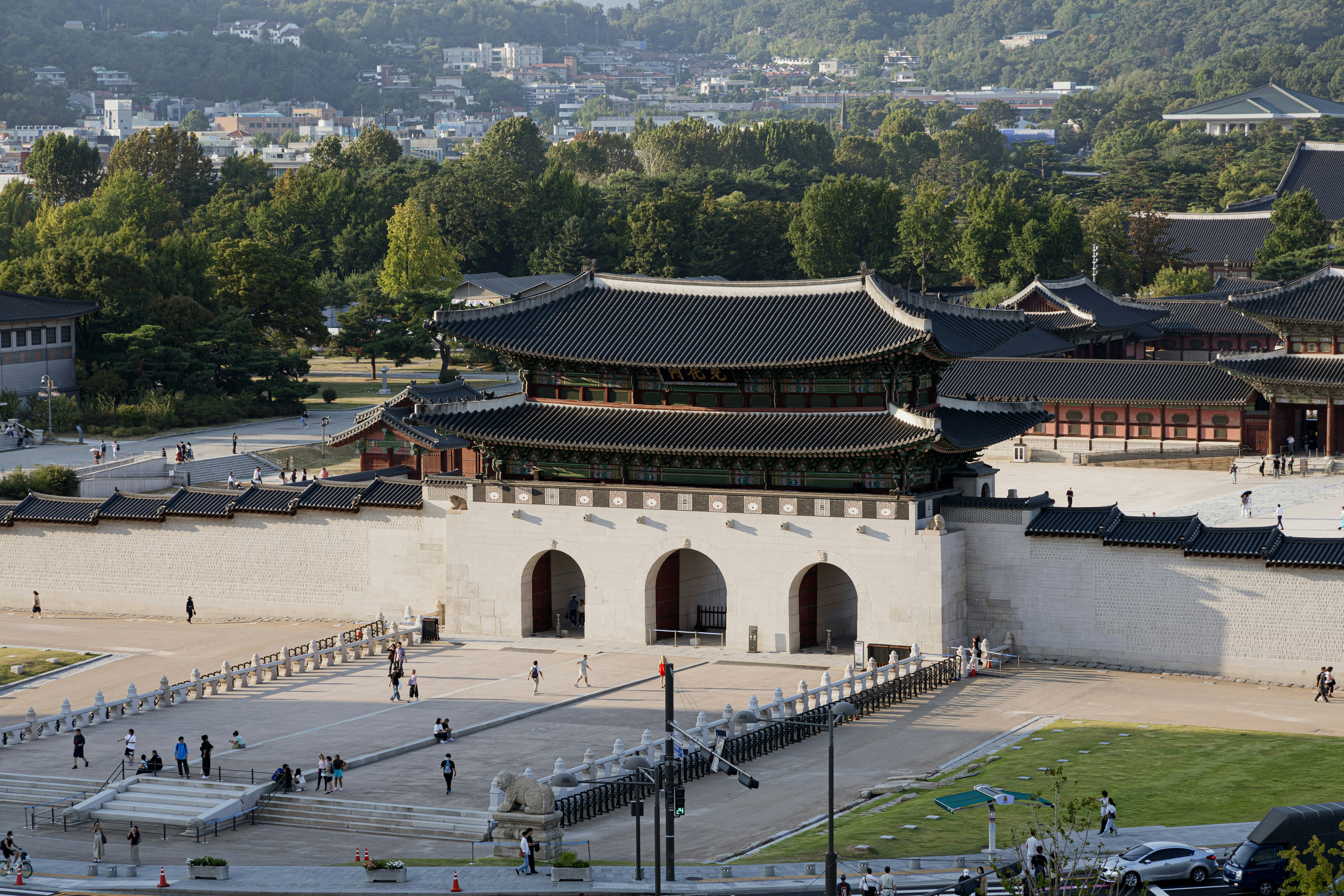 Gwanghwamun Gate at Gyeongbokgung Palace in Seoul with people walking in the courtyard