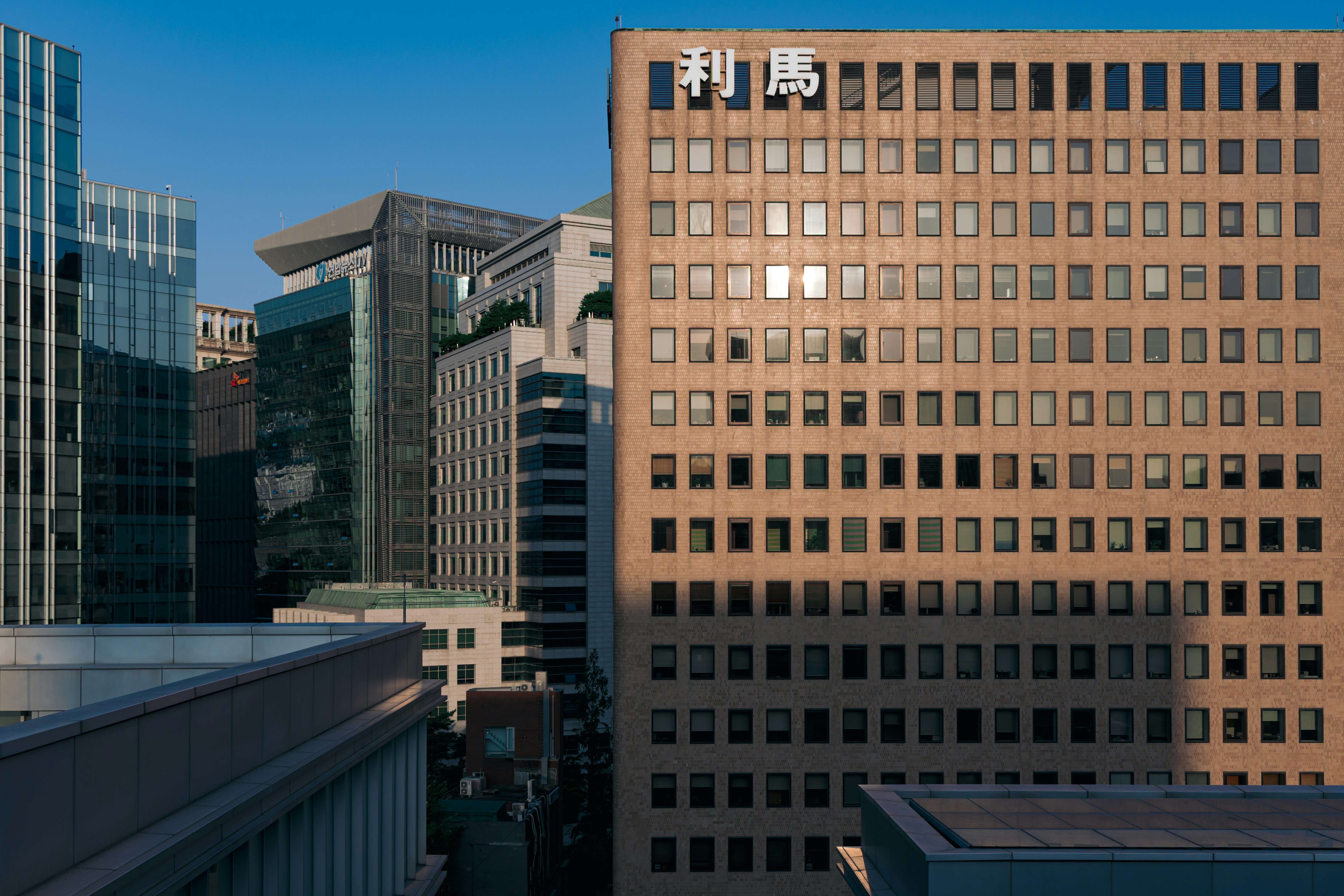 A tan office building with many windows and Chinese characters on the facade