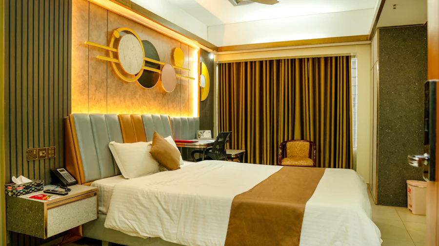 Hotel bedroom with a desk and gold wall art (stock placeholder)