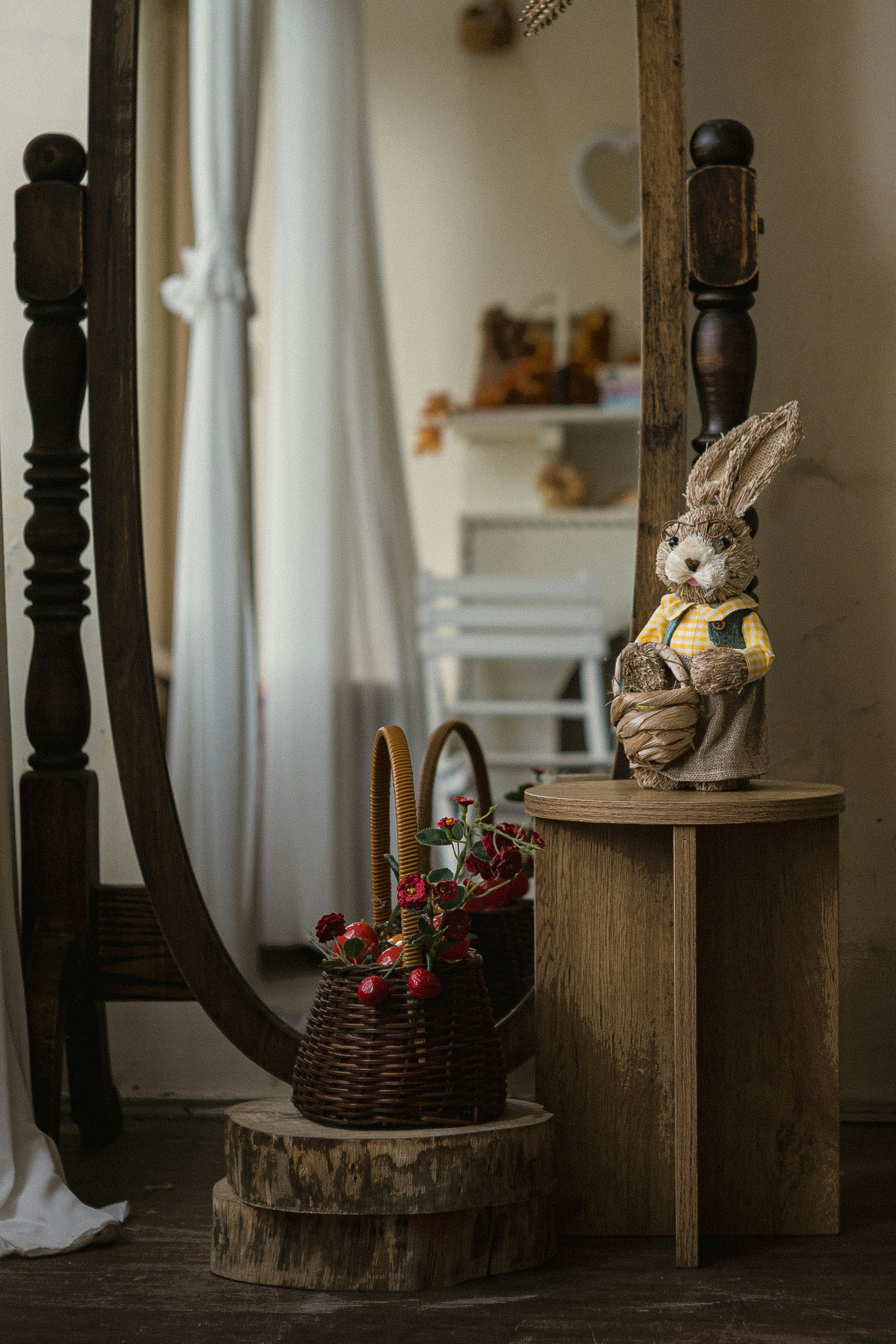 A decorative burlap rabbit figurine and a small wicker basket of red flowers