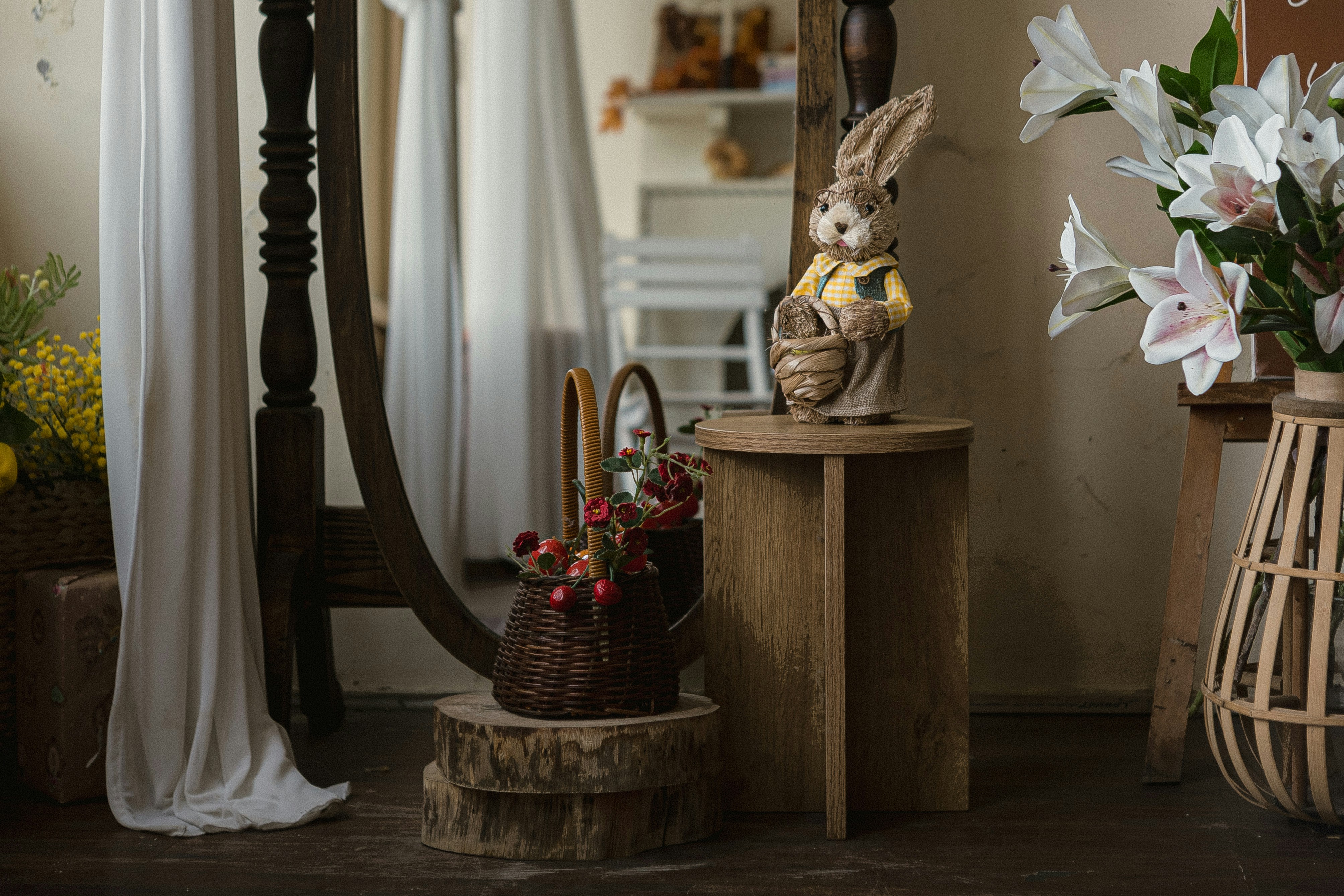 A decorative rabbit figurine and a small basket of red berries on wooden stands
