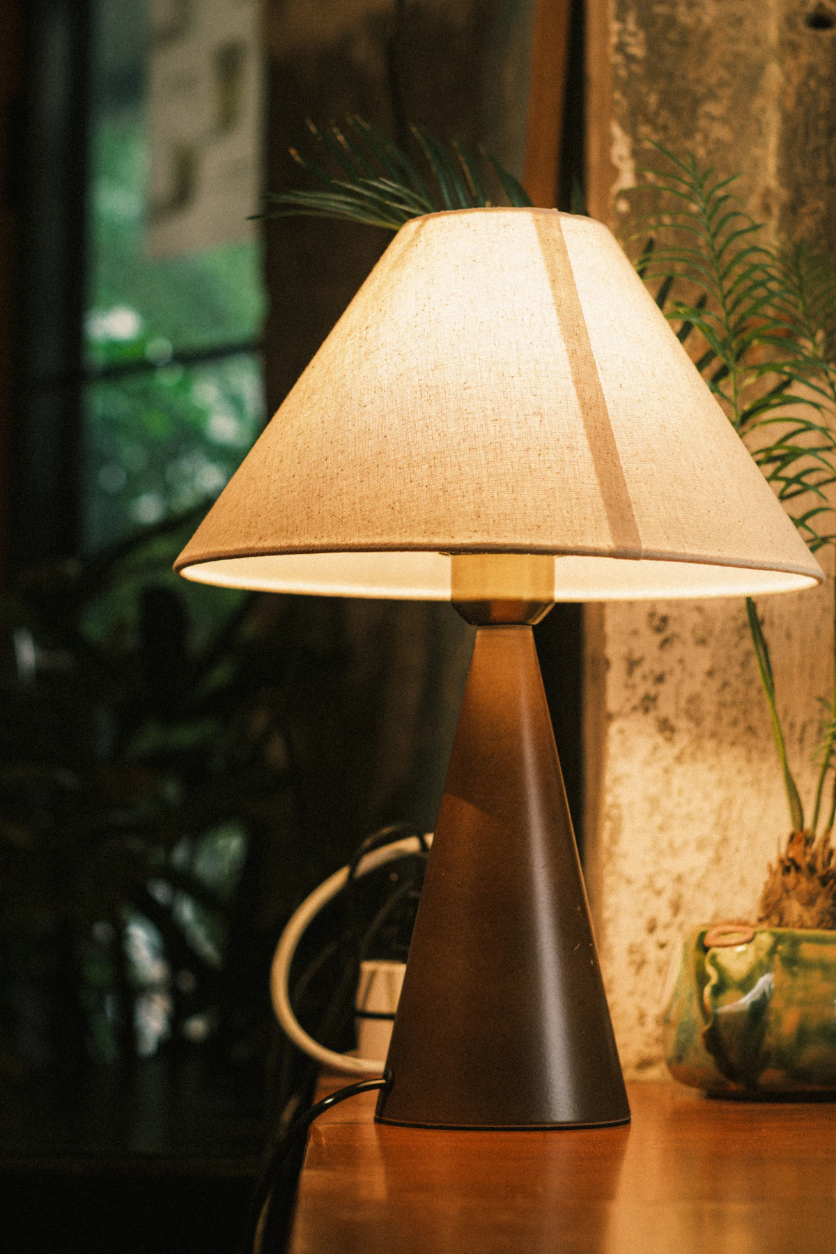 Lampu meja menyala di atas permukaan kayu