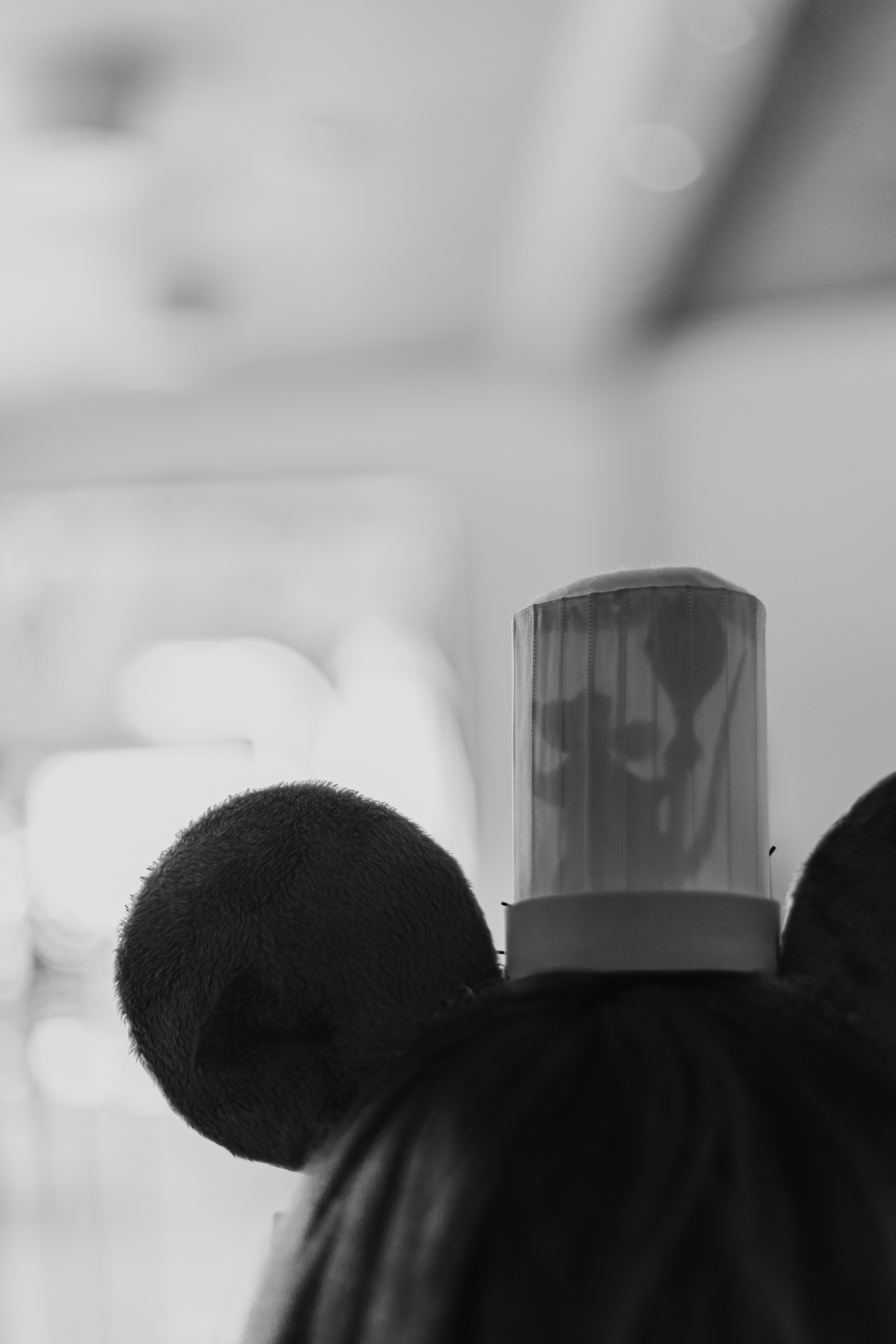 A person wearing a headband with a small cylindrical light and fuzzy ears