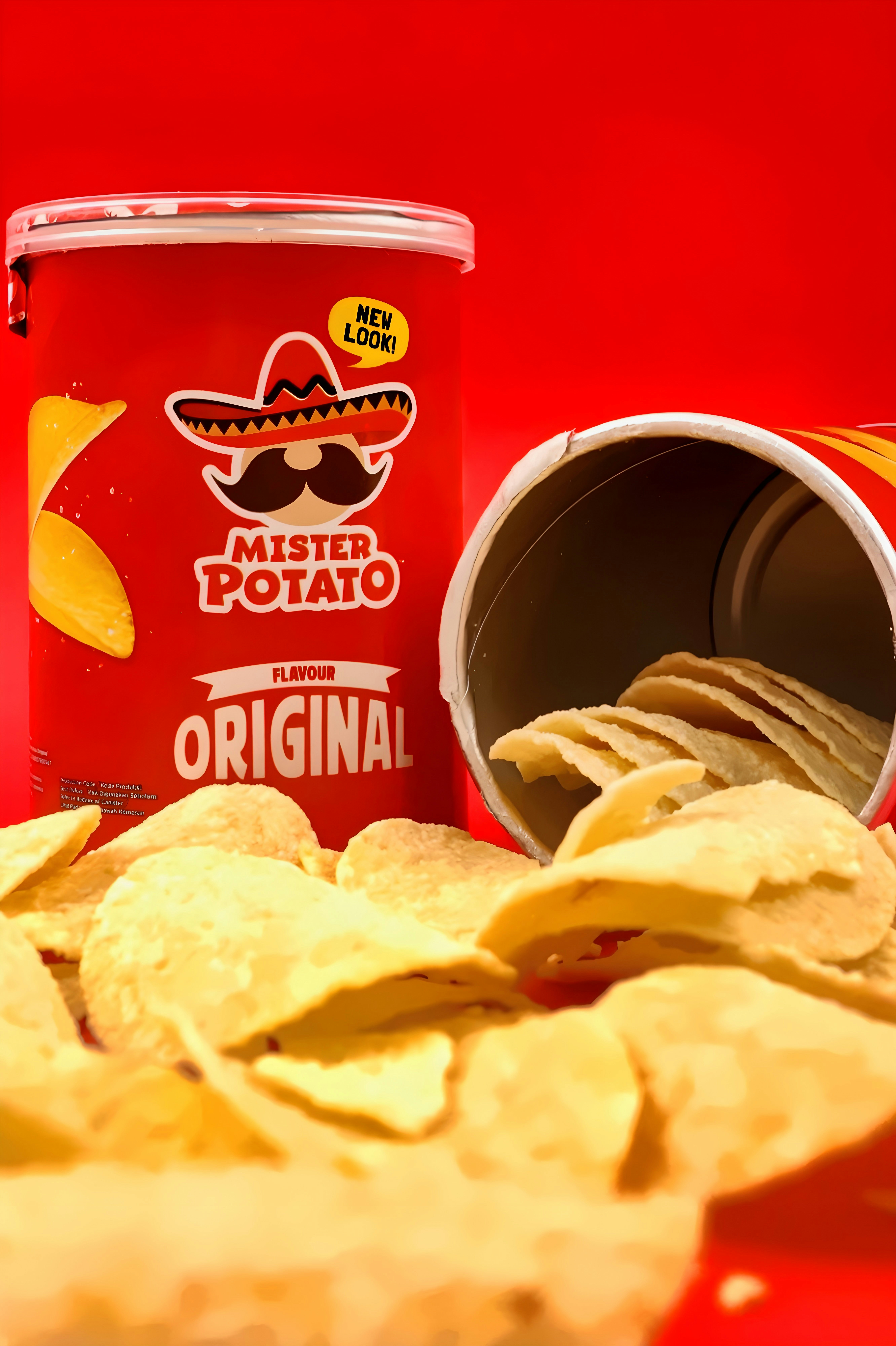 A red canister of potato chips with a spilled pile of chips