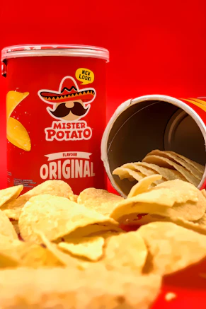 A red canister of potato chips with a spilled pile of chips