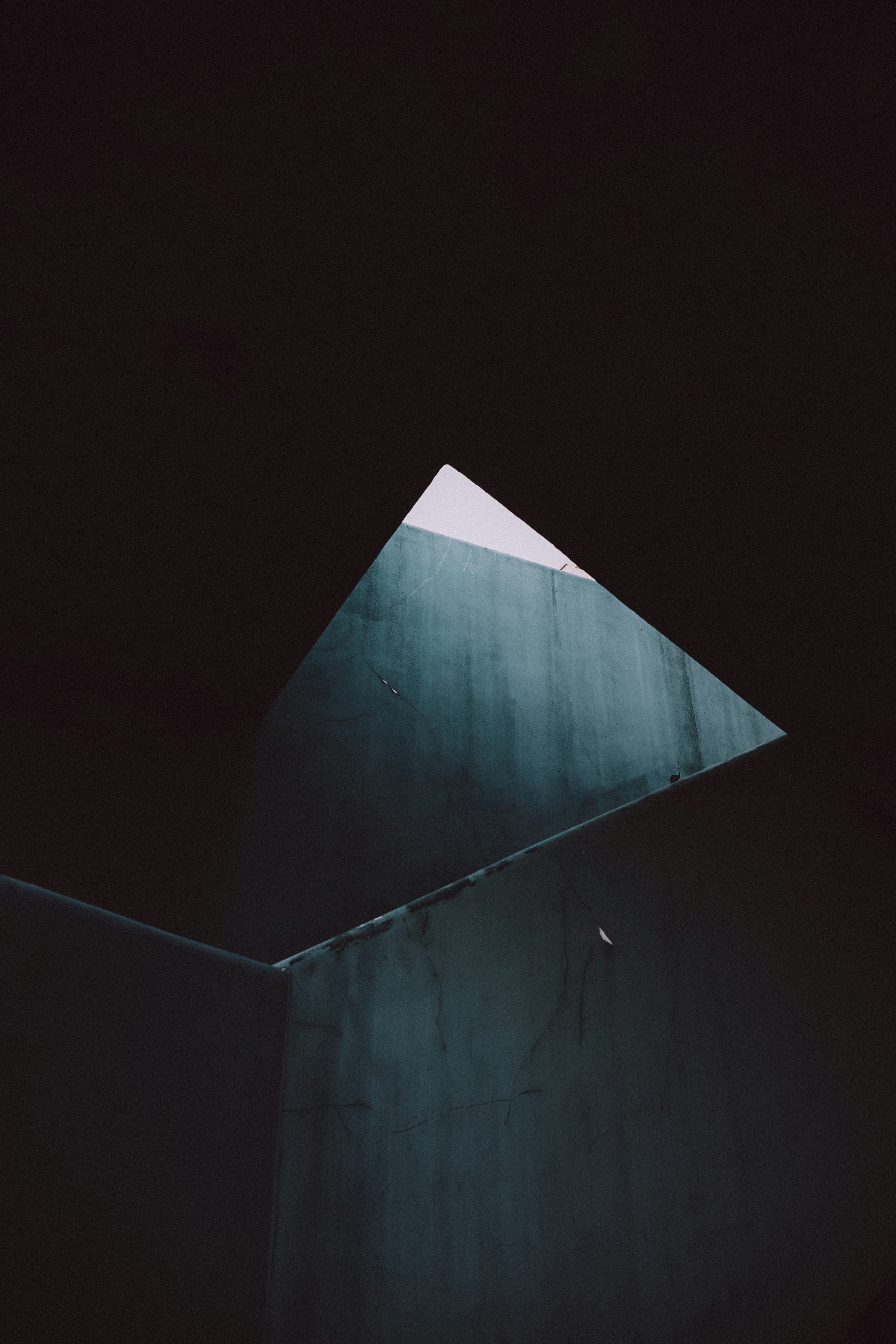 A triangular patch of sky framed by dark concrete walls