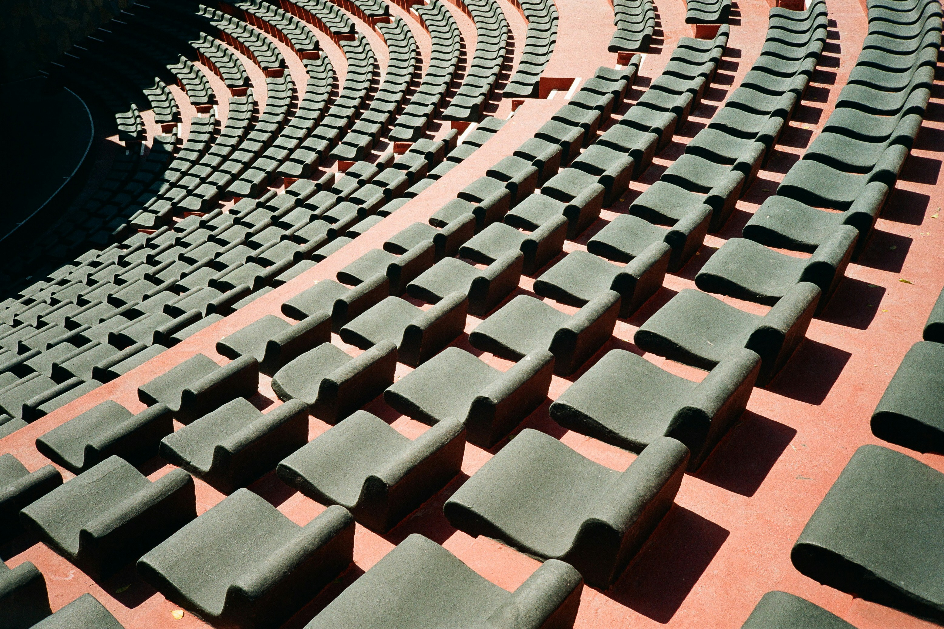 Rows of empty dark seats in the ancient amphitheater of Bodrum, Türkiye