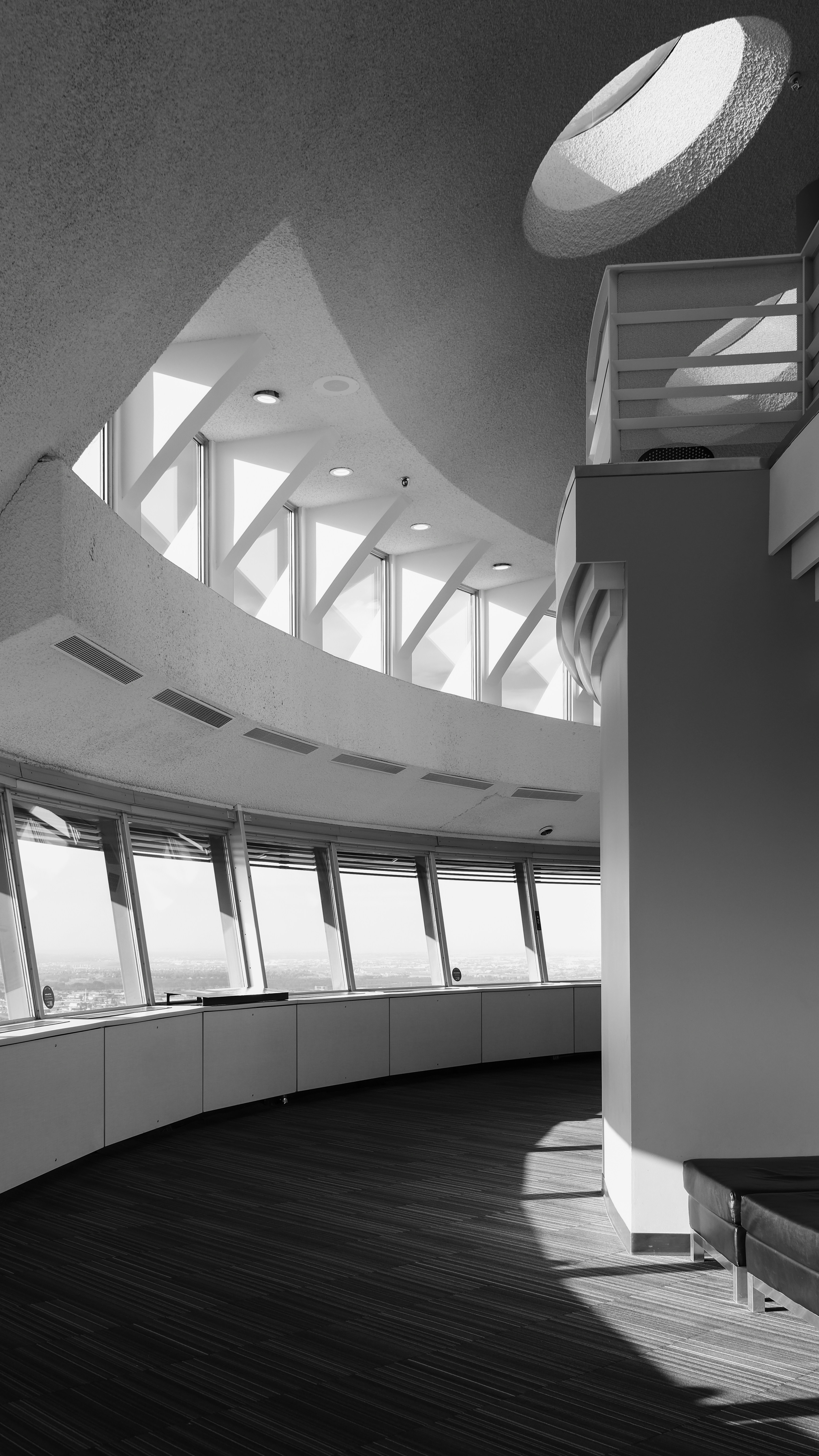 A curved interior observation deck with floor-to-ceiling windows and a circular ceiling cutout