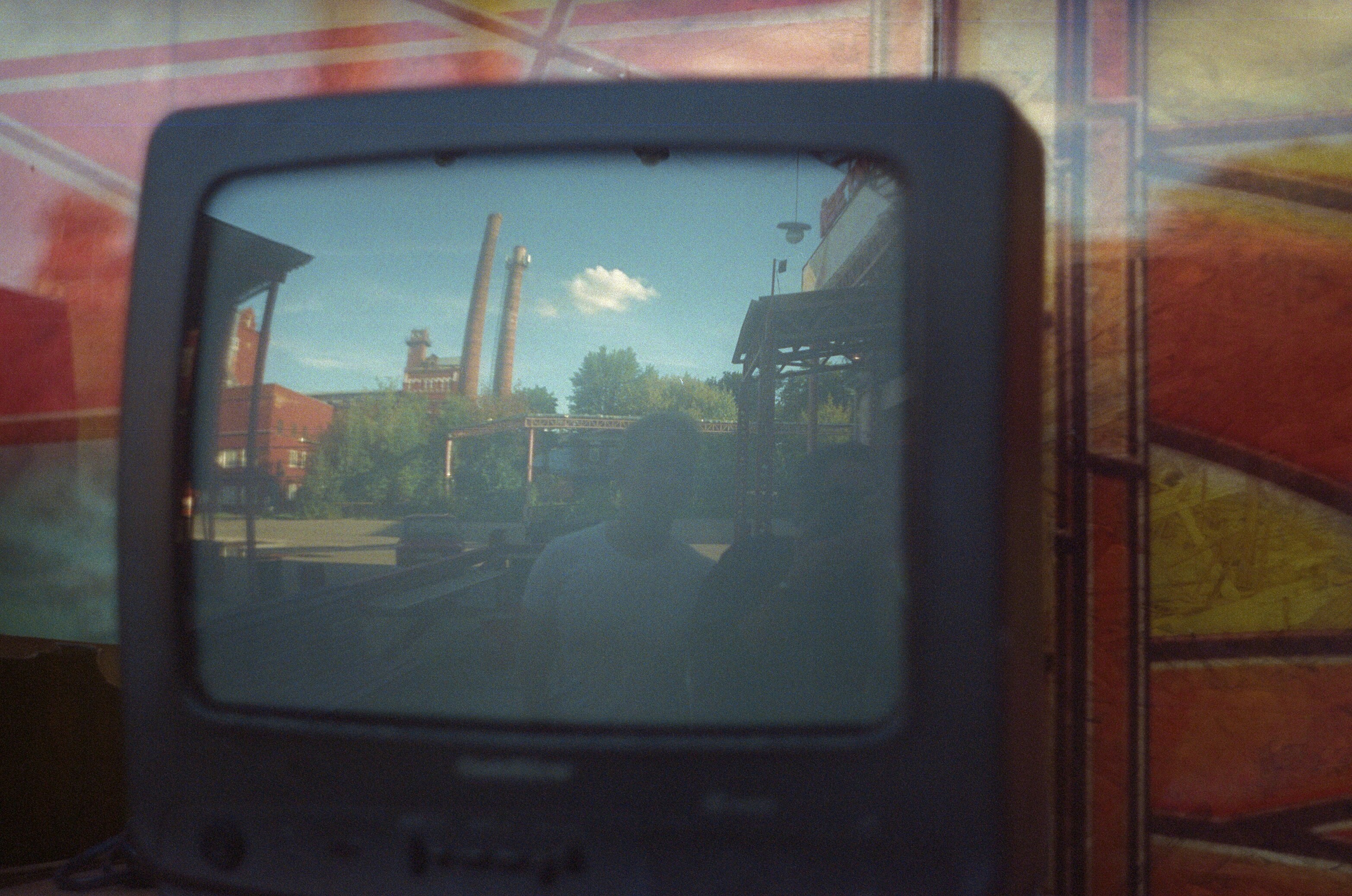 A reflection of a factory with two smokestacks in a vintage television screen