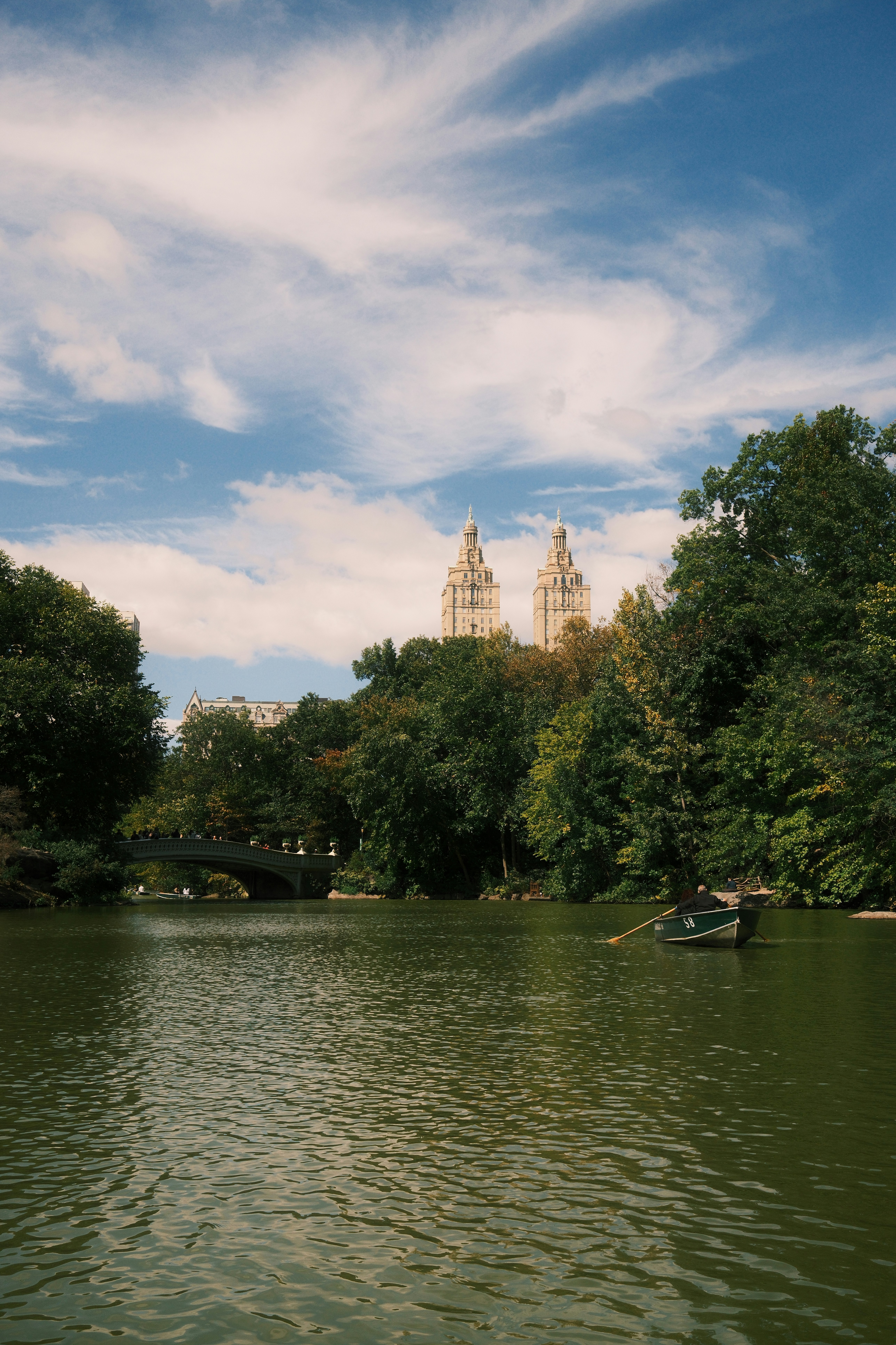A rowboat on The Lake in Central Park with the San Remo towers behind