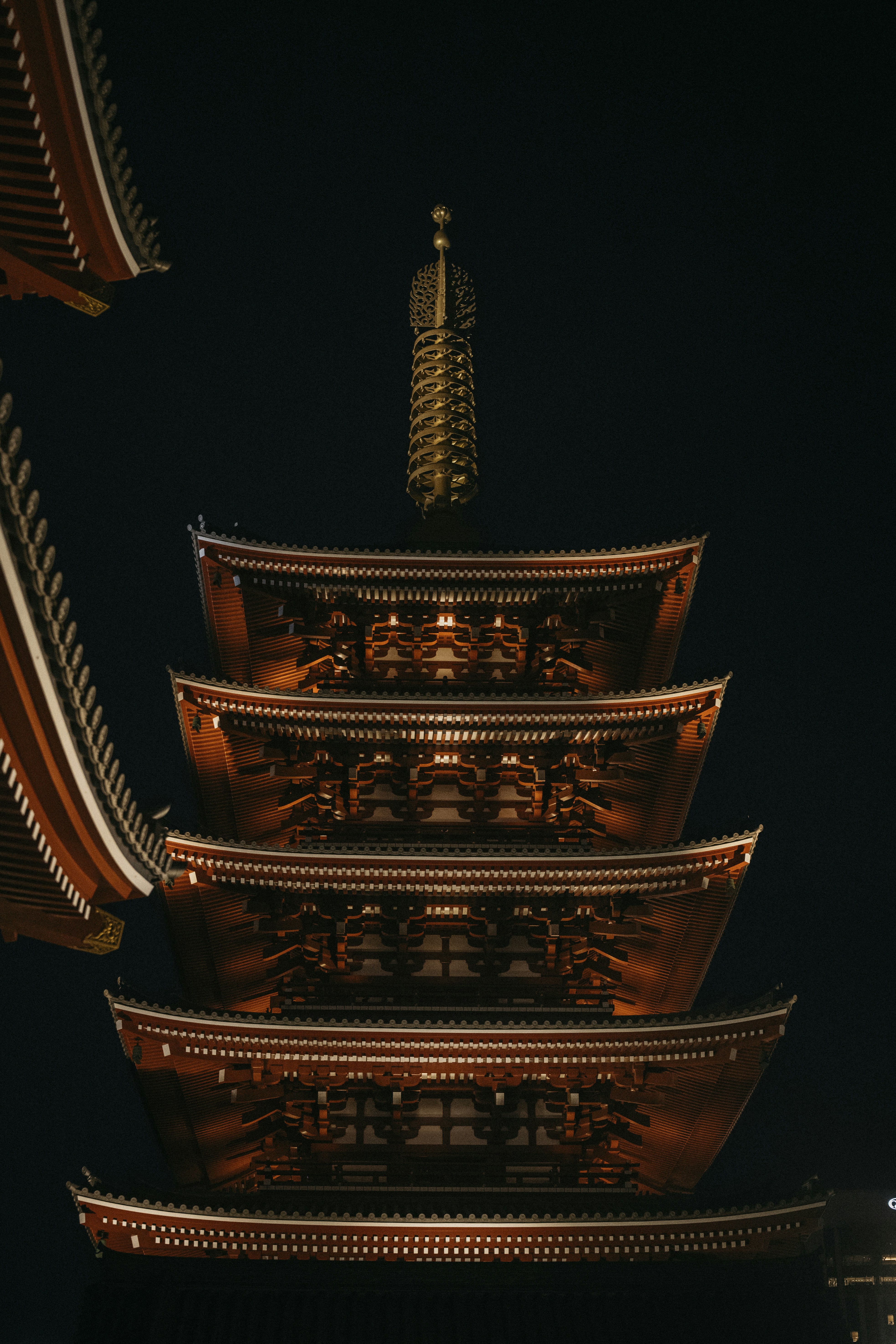 A five-story pagoda illuminated at night against a dark sky