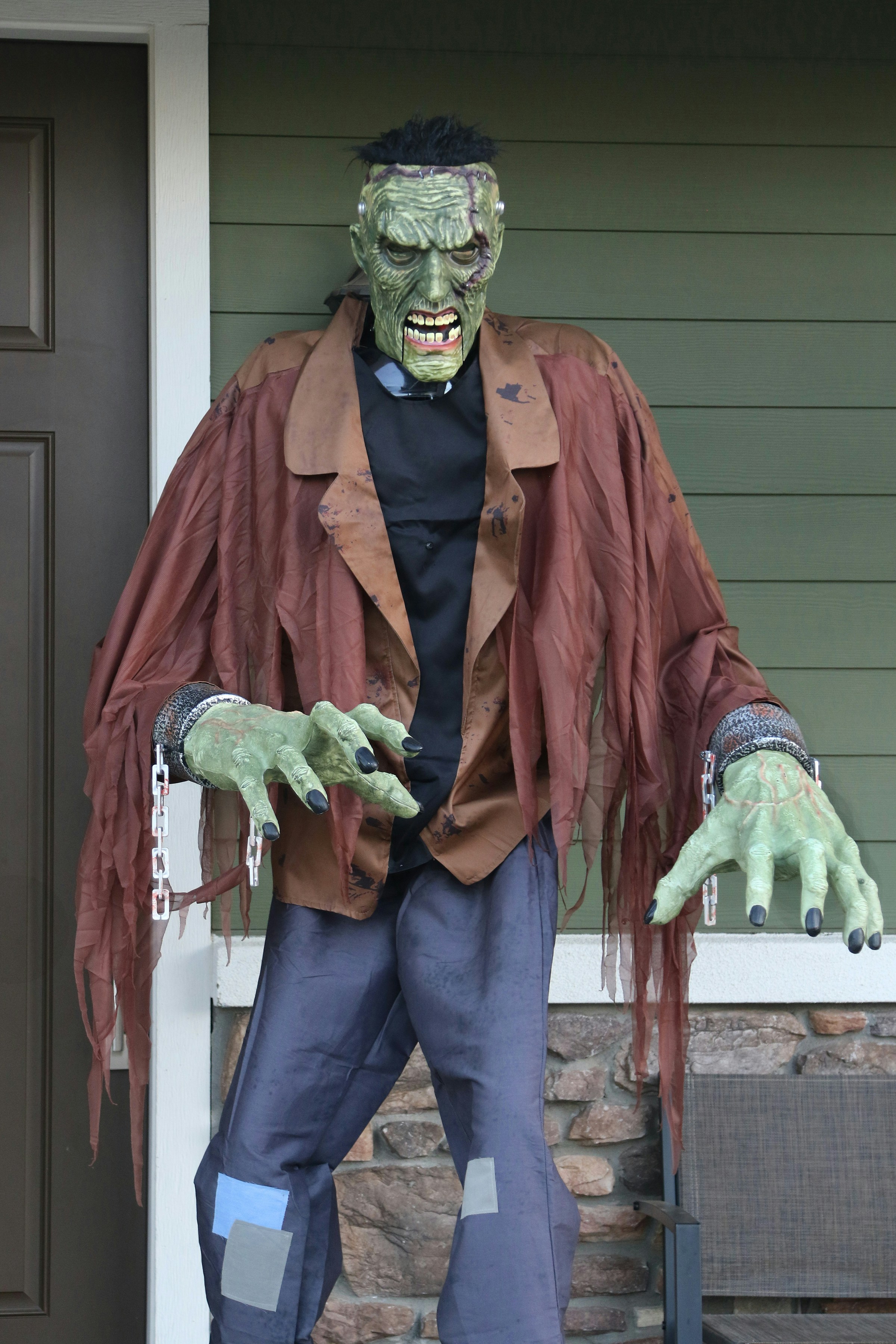 A Frankenstein monster prop with green skin and chains on its wrists