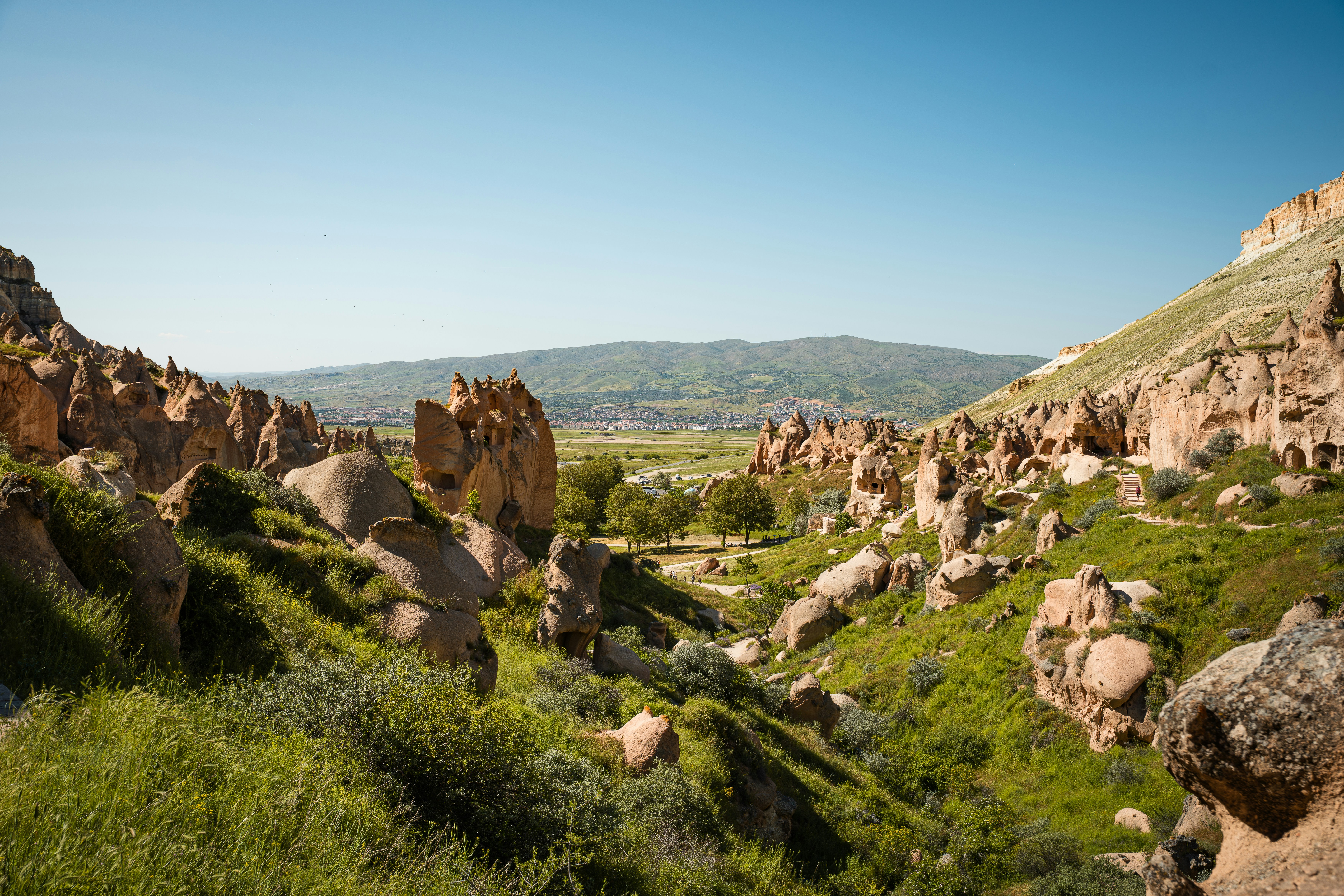 Rock formations and green hills in the Cappadocia region of Turkey