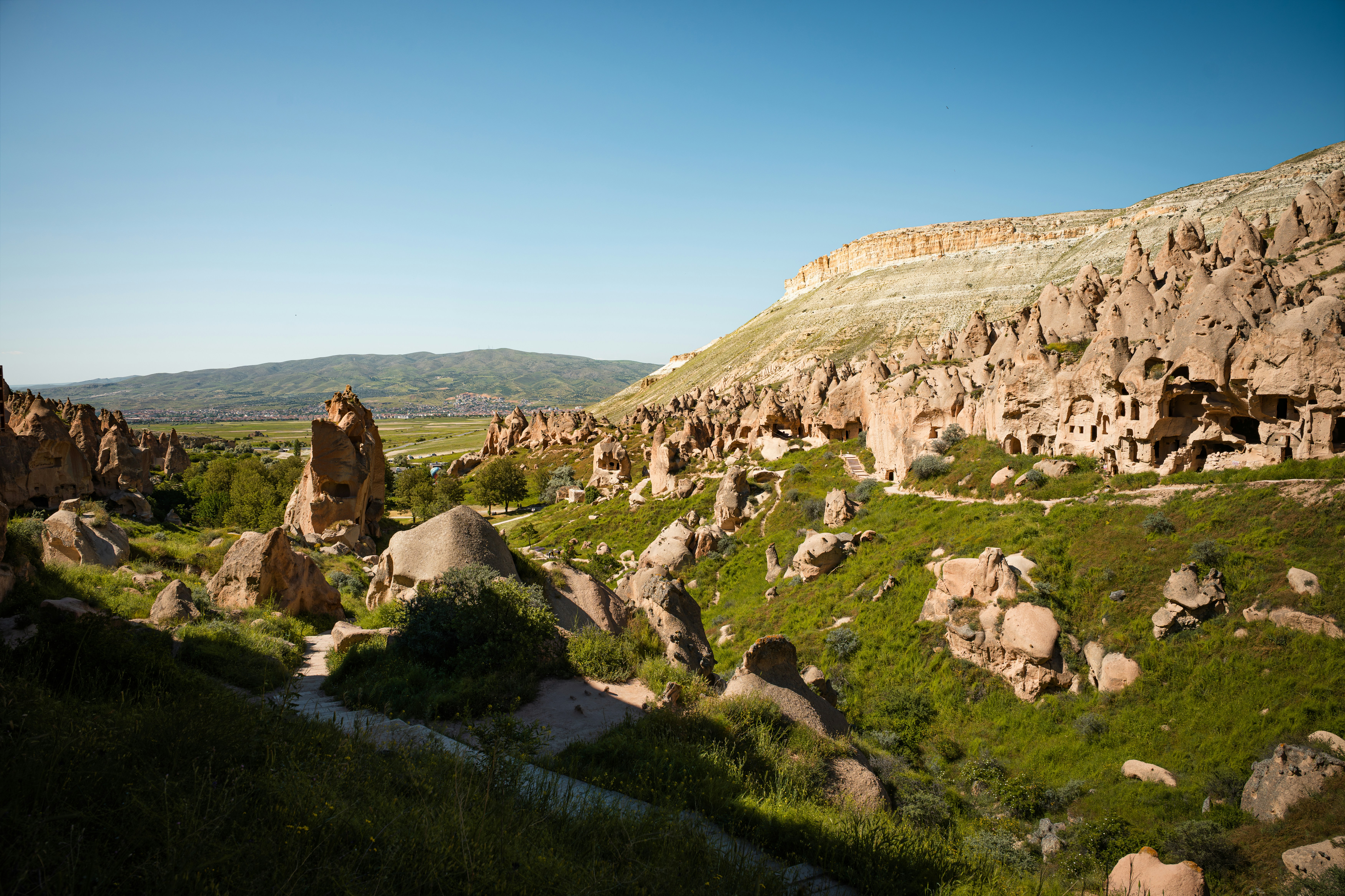 Tuff rock formations and cave dwellings in the green valley of Cappadocia, Turkey