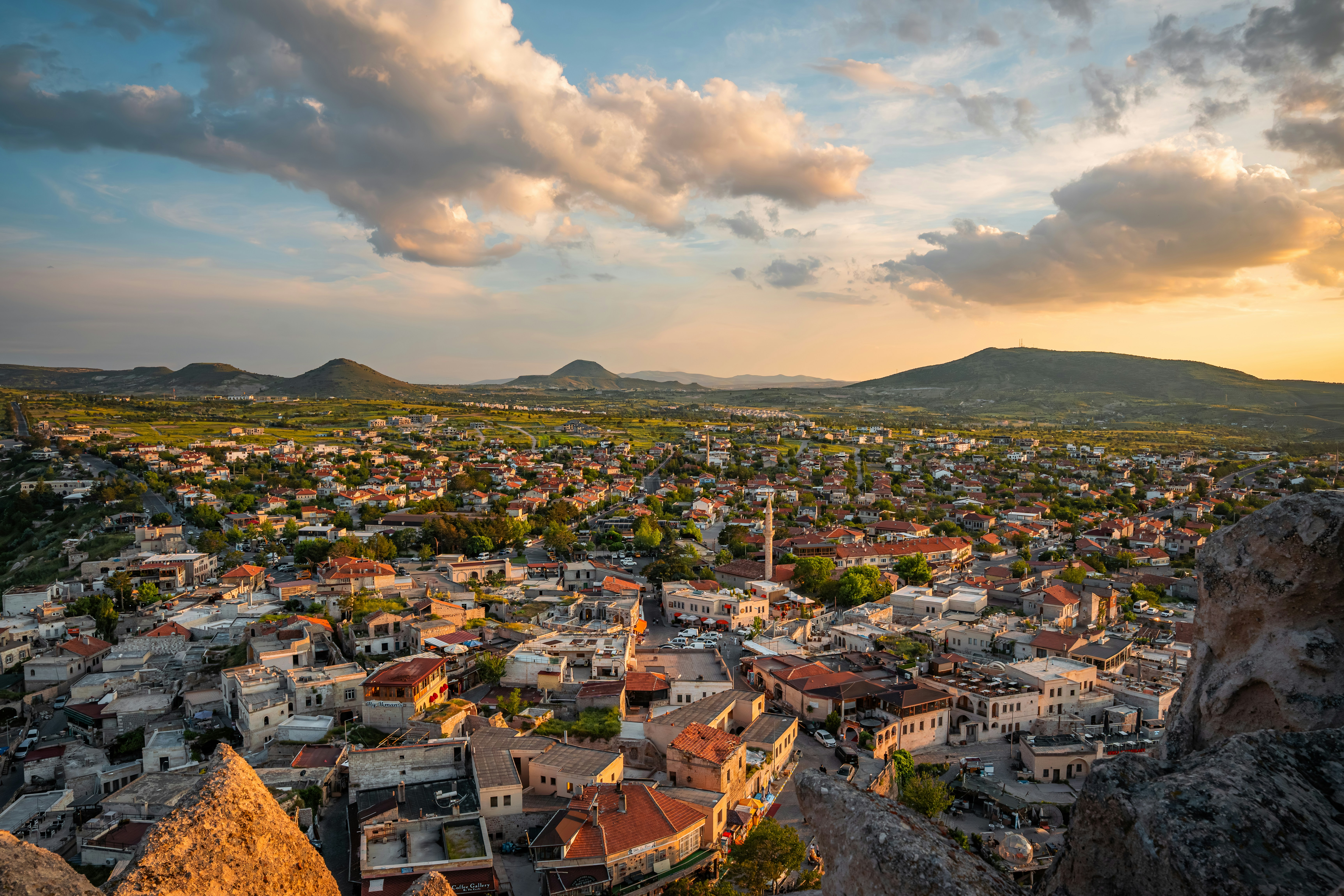 Aerial view of the town of Ortahisar in Cappadocia under a warm golden sky