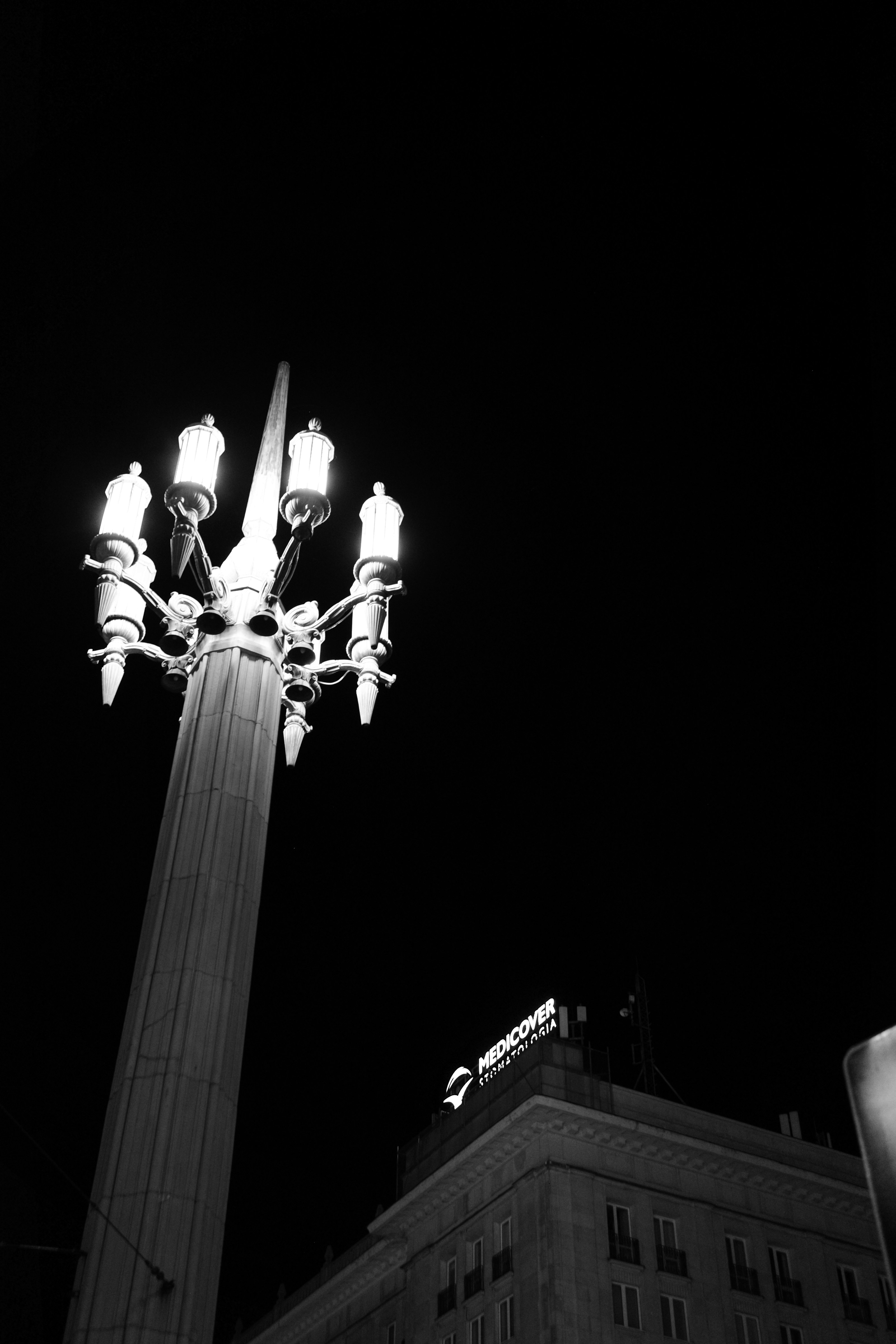A tall ornate street lamp glowing against a dark night sky