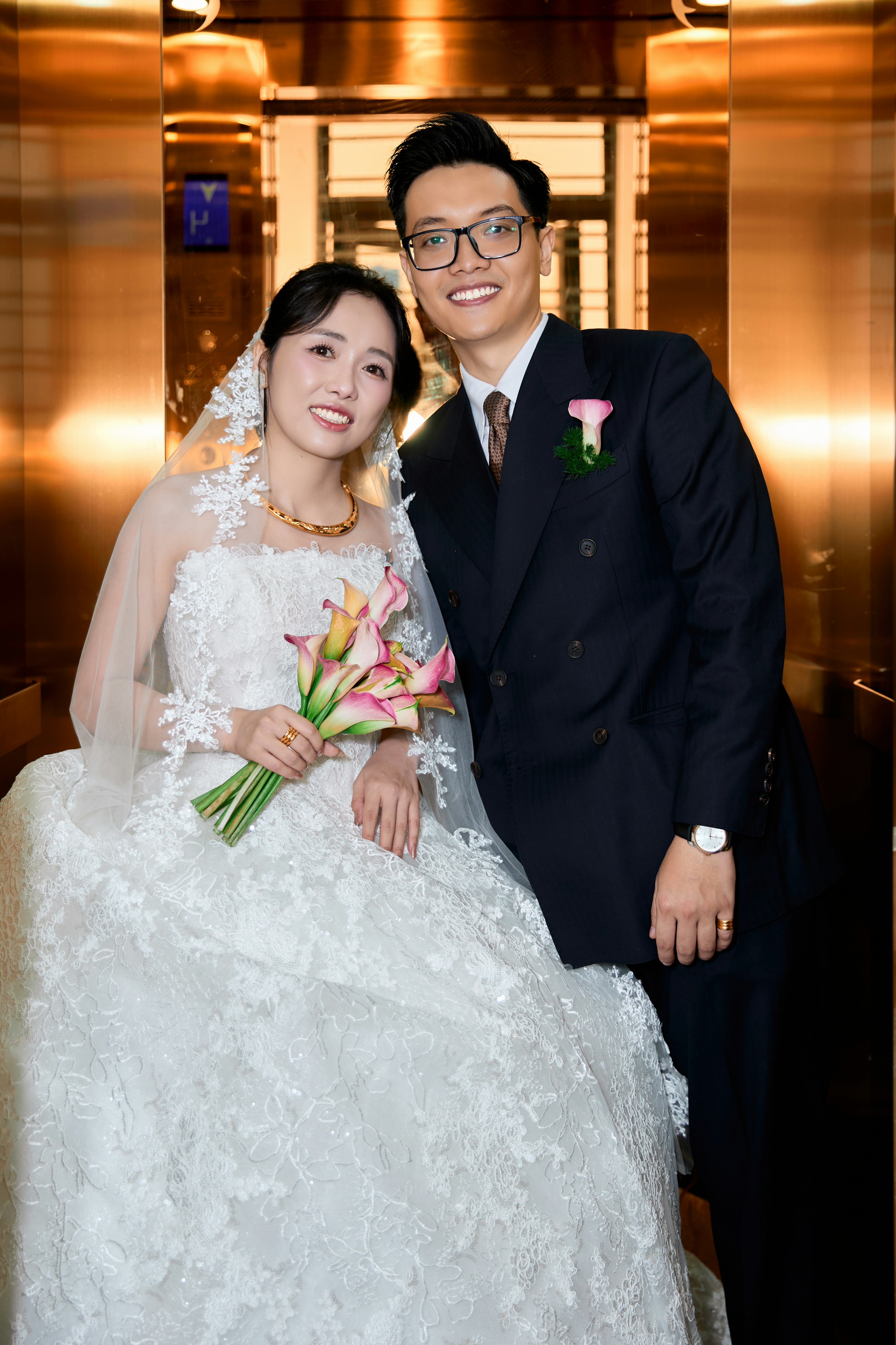 A bride in a white lace gown and a groom in a dark suit