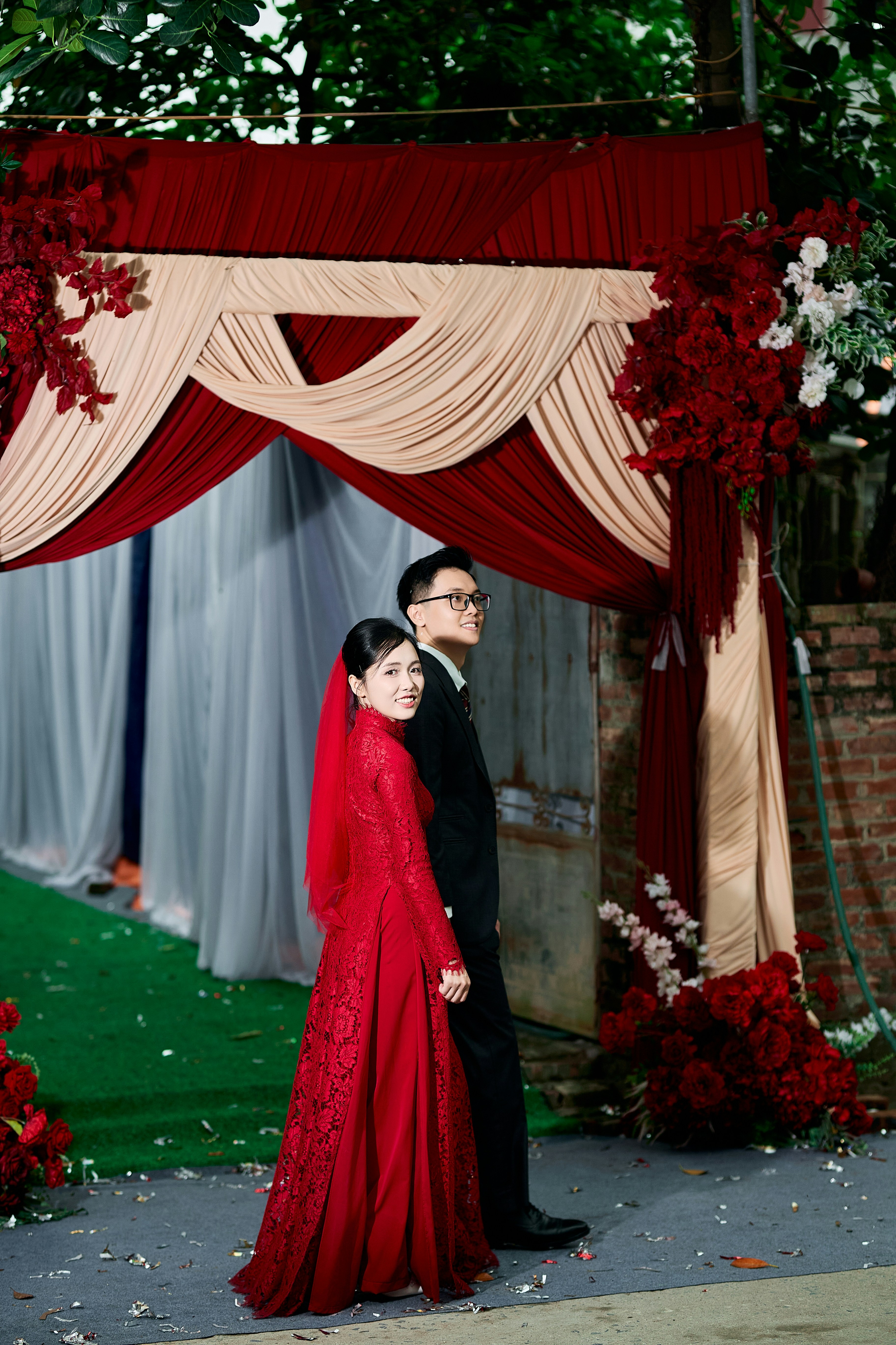 A woman in a red lace dress and a man in a black suit
