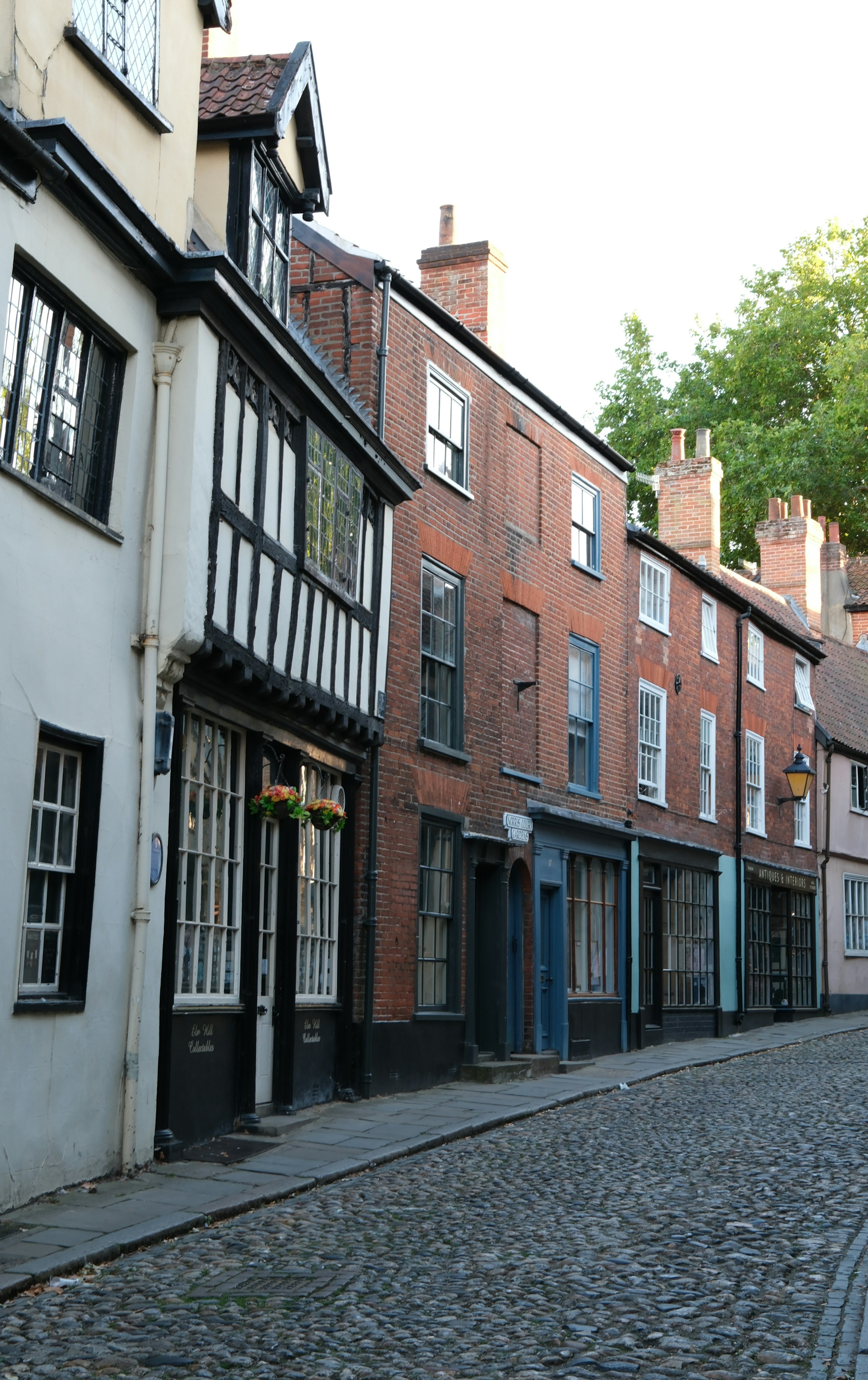 A cobblestone street lined with historic timber-framed and brick buildings