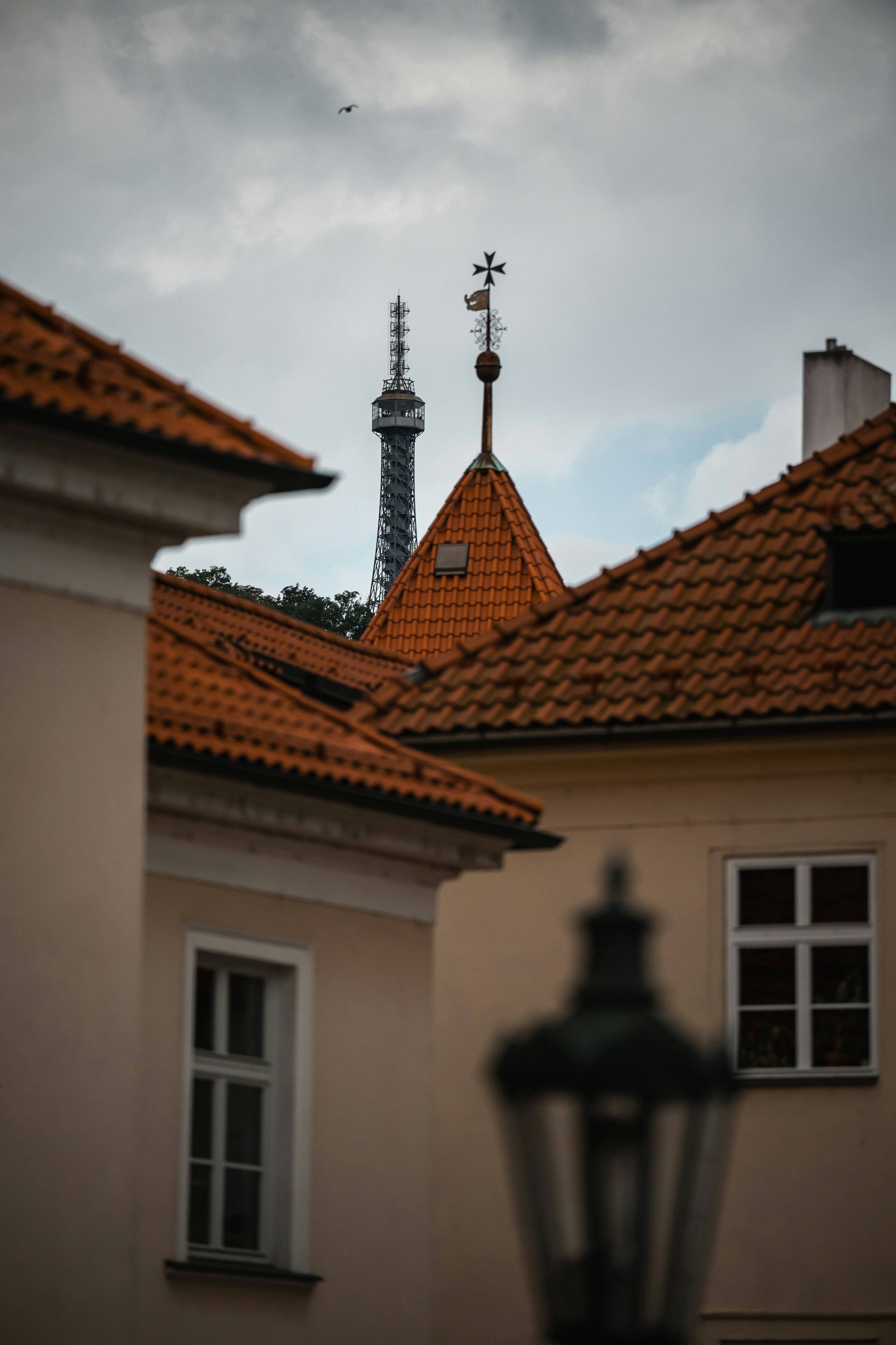 The Petřín Lookout Tower rising above orange tiled roofs in Prague