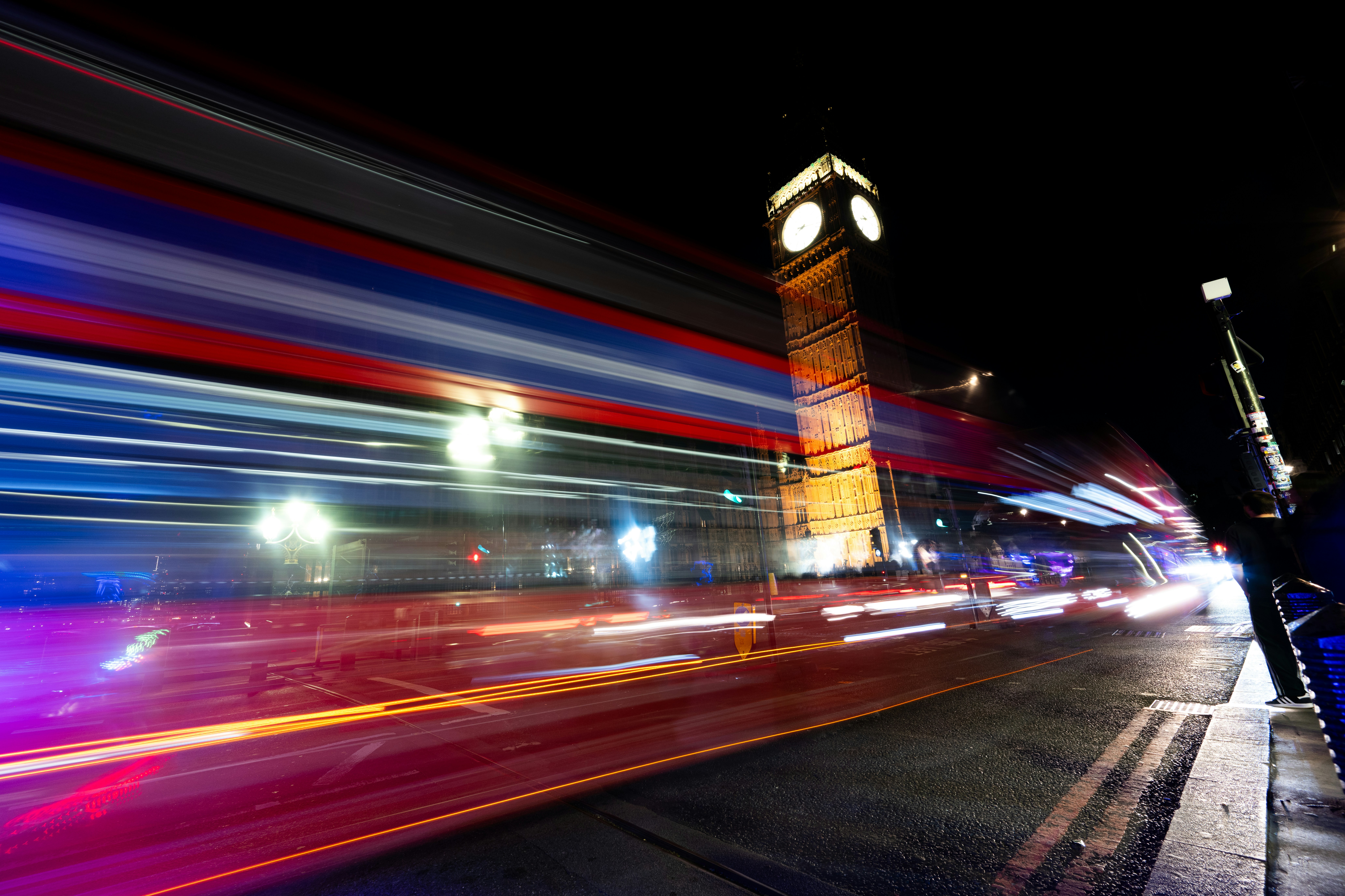 Long exposure light trails from traffic passing Big Ben in London at night
