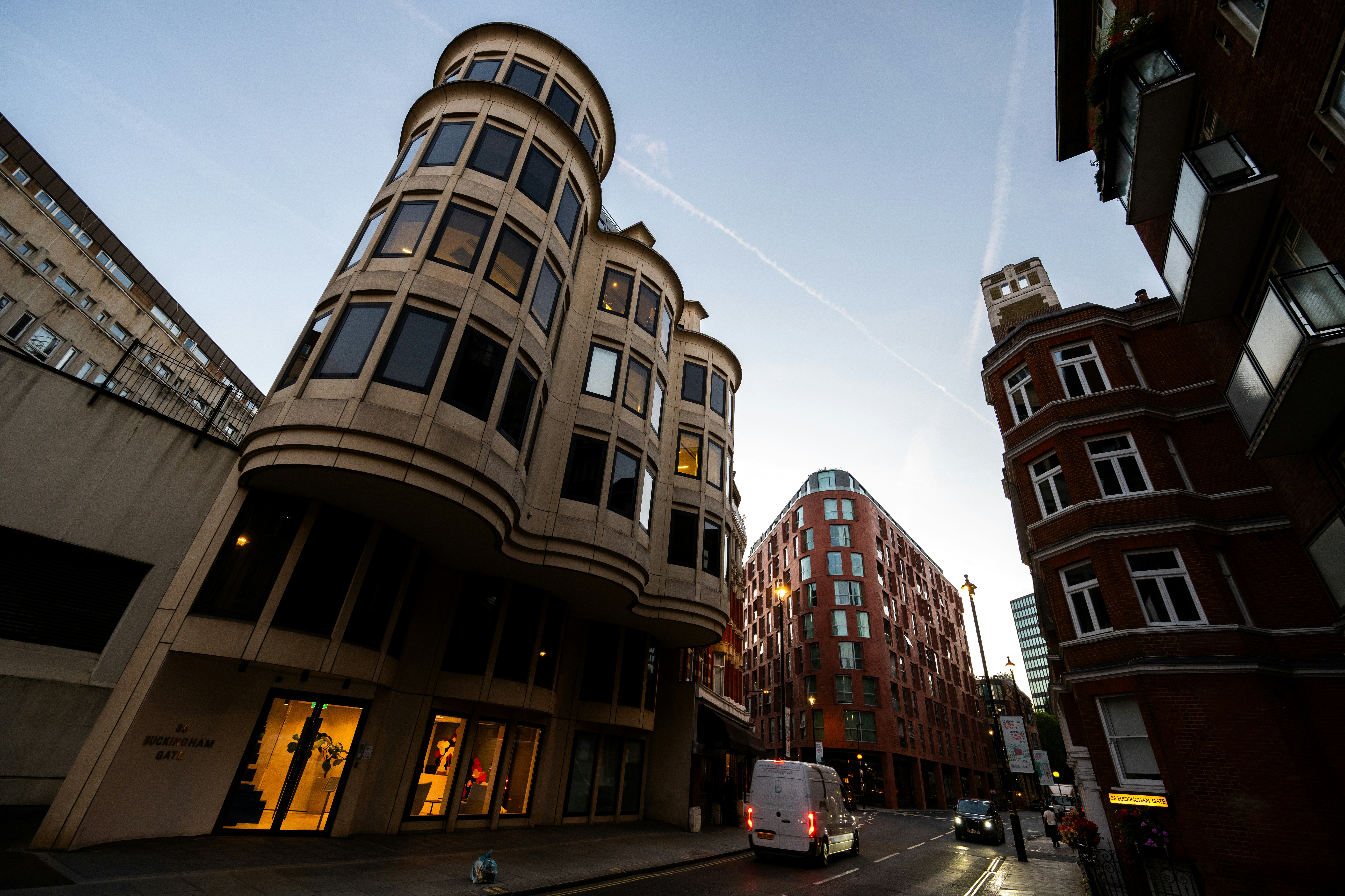 Modern and brick buildings along a street in London with a white van