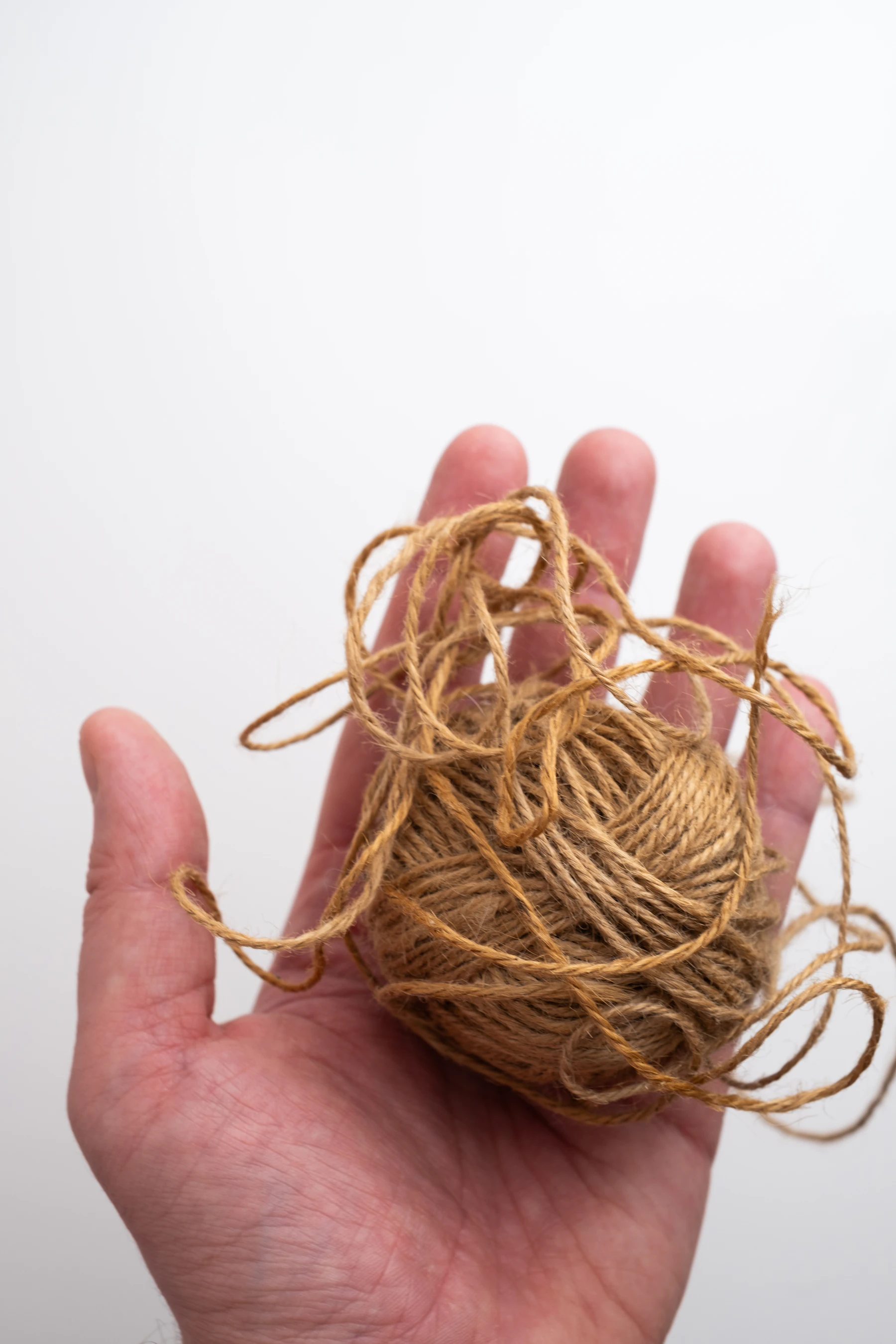 A loose ball of jute twine held in an open palm