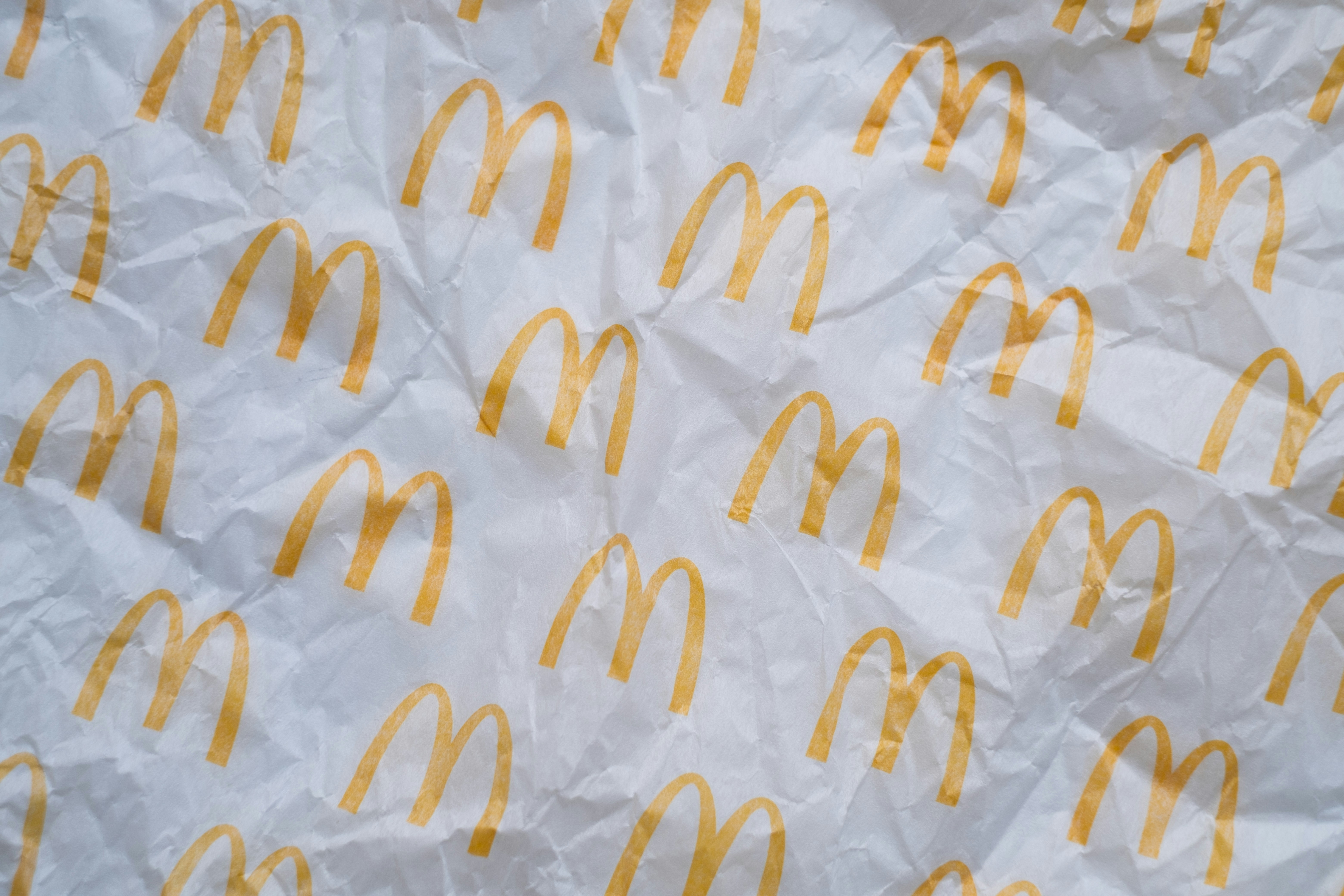 Yellow golden arches logos printed on white crumpled paper