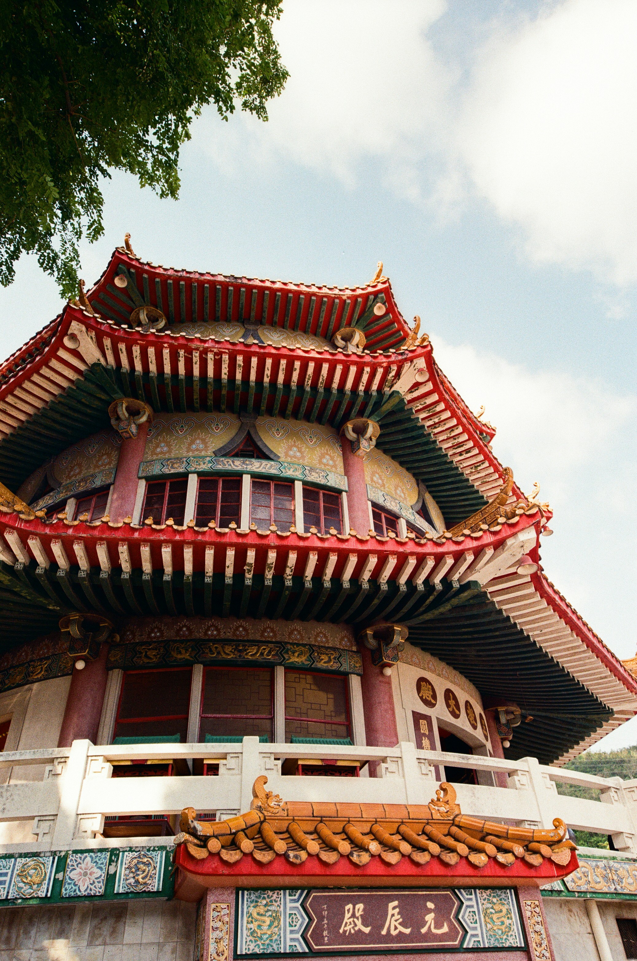 A multi-tiered pagoda with red eaves and ornate details under a bright sky