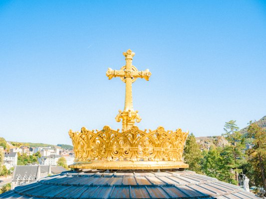 The gilded crown and cross on the basilica — Lourdes, France