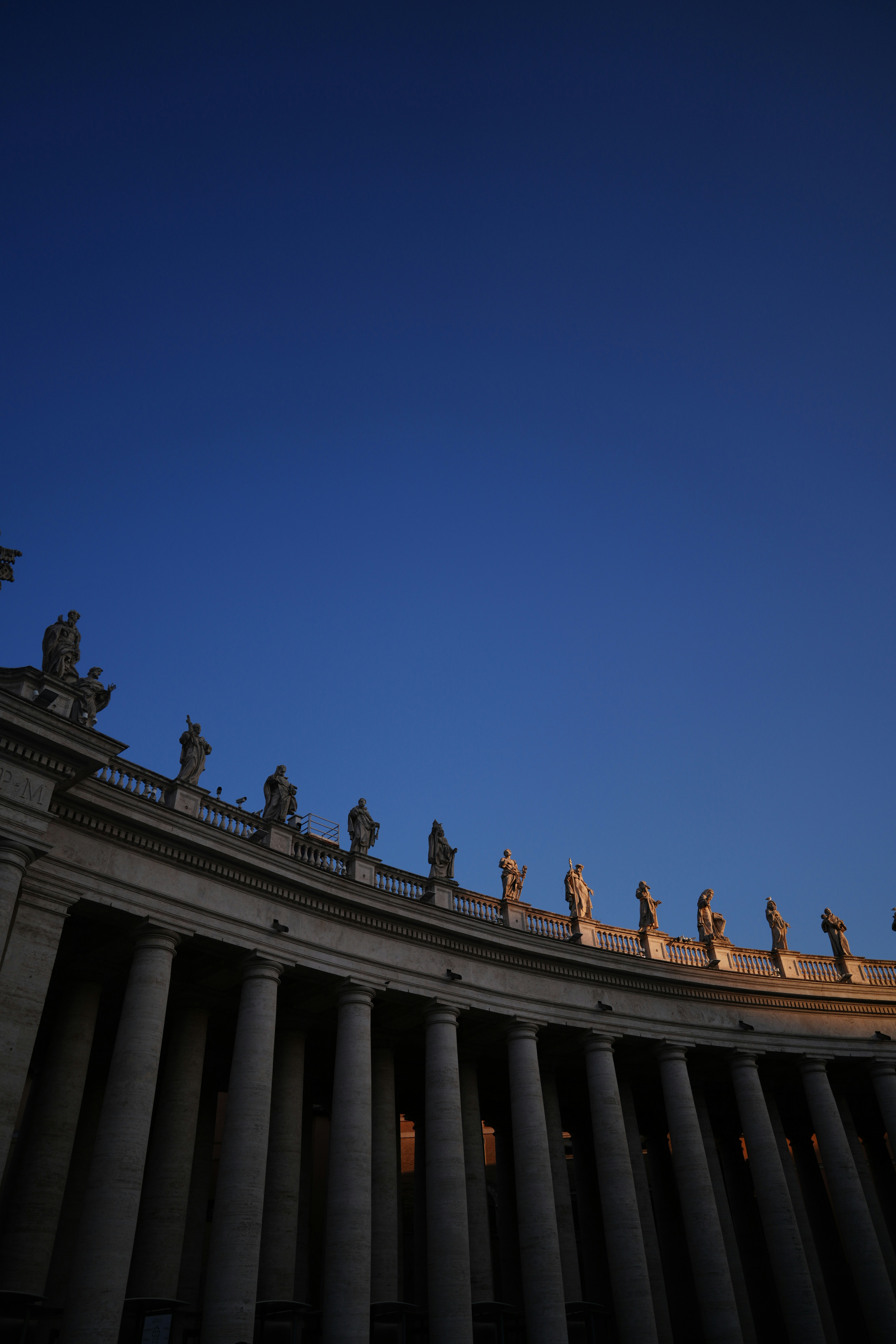 Stone statues atop the curved colonnade of Saint Peter's Square in Vatican City
