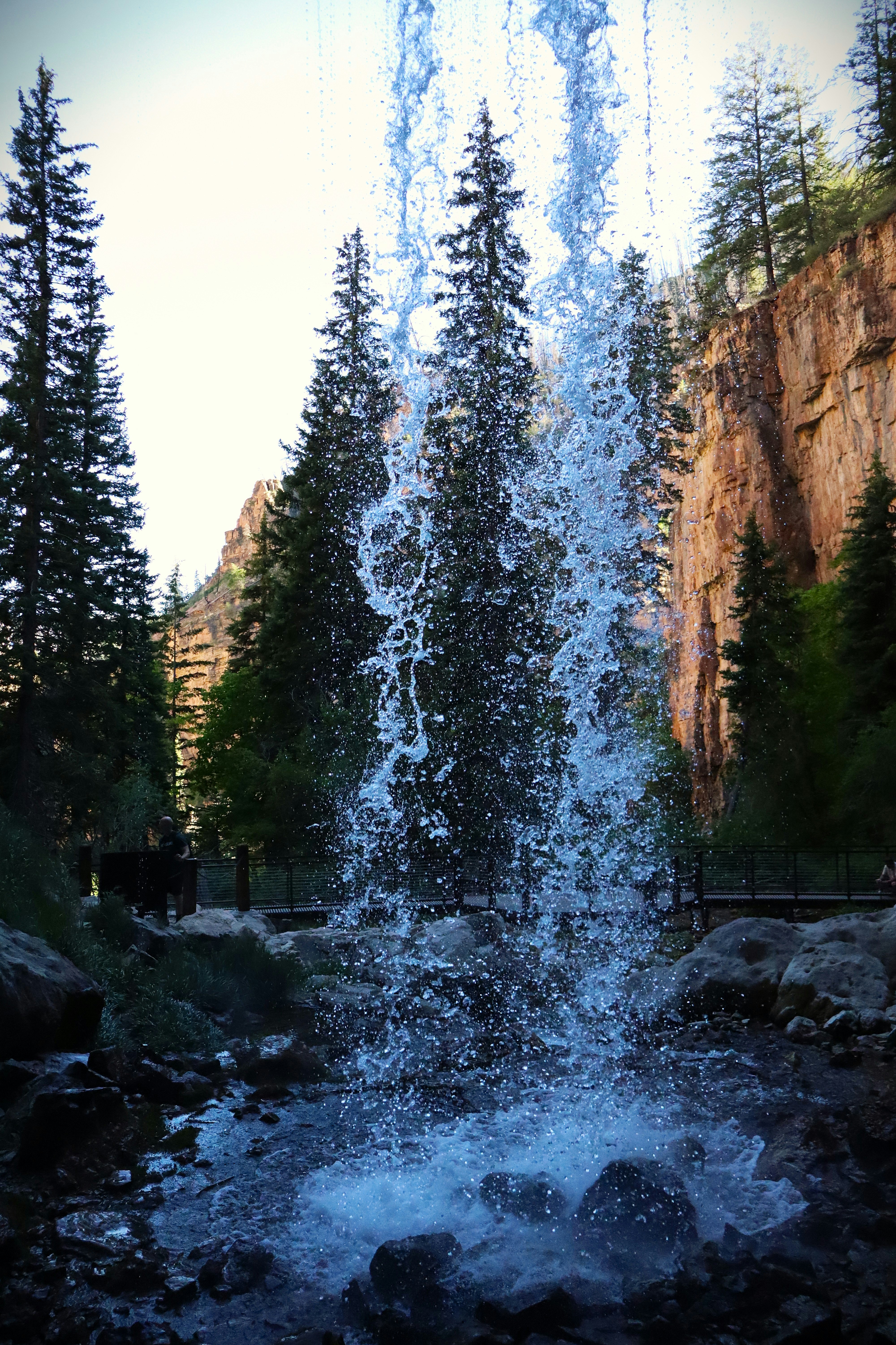 Waterfall over rocky cliff and bridge - Free Photo on Unsplash