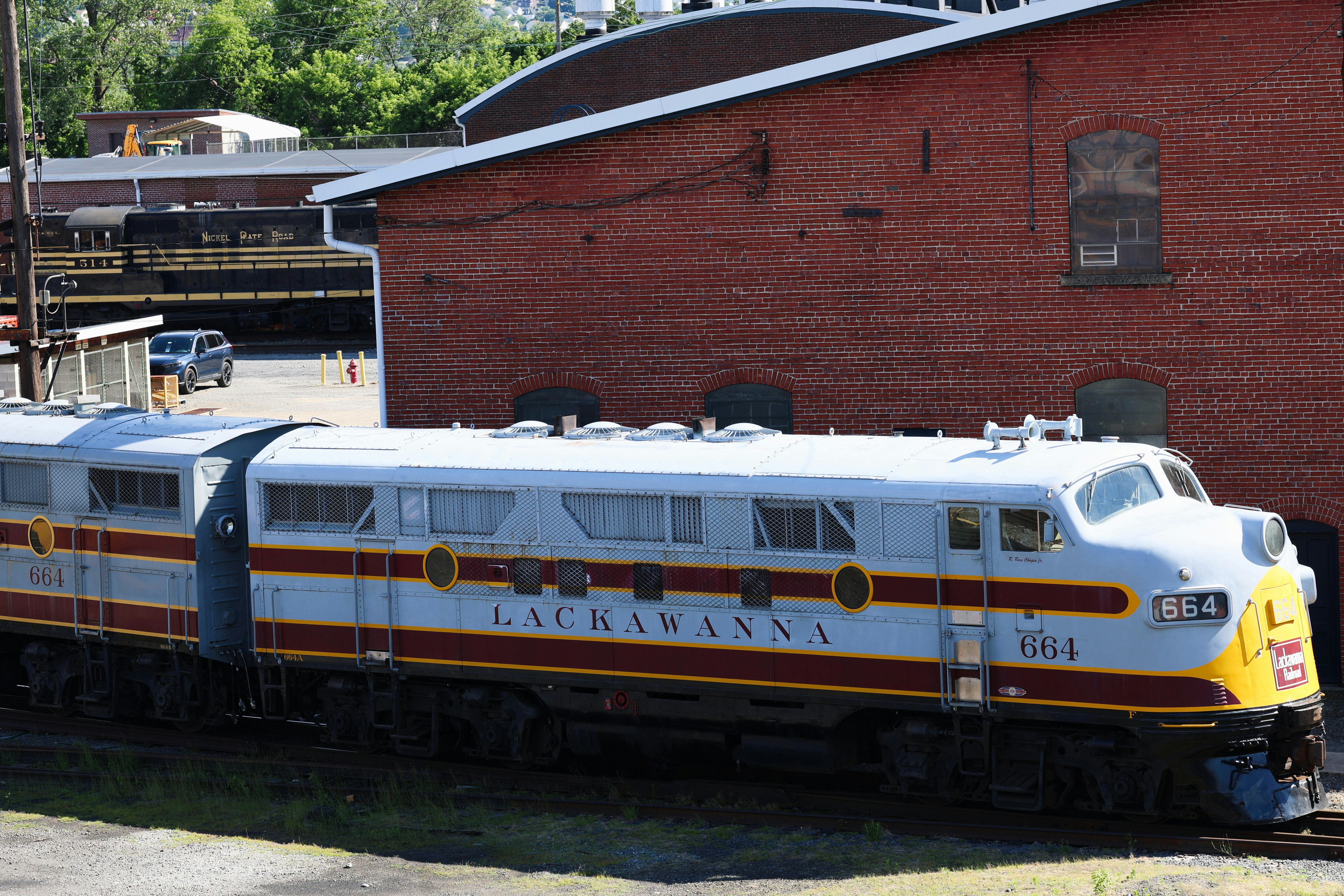 A vintage Lackawanna diesel locomotive on tracks beside a red brick building